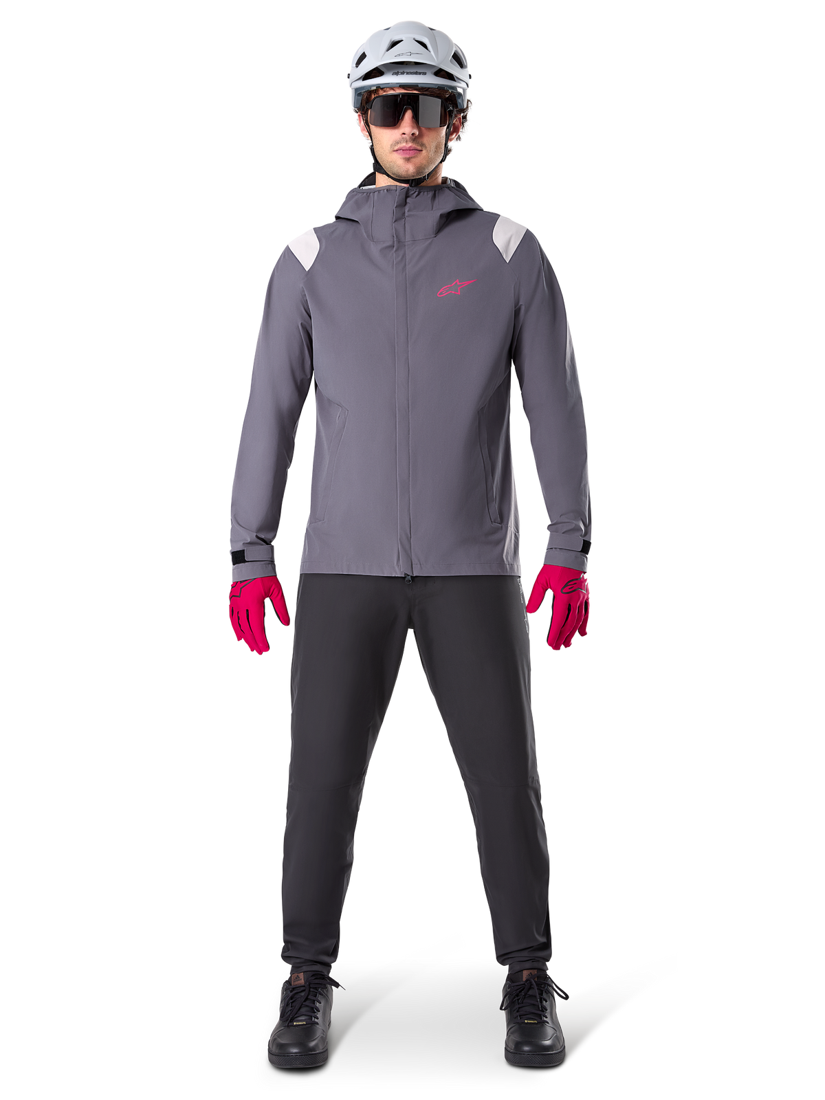 Alpinestars A-Dura regnjacka, mountainbikejacka, Dark Titanium-grå med rosa logotyp, bärs med grå MTB-hjälm och klarrosa handskar, skyddande 2,5-lagers membrankonstruktion för cykling i vått väder
