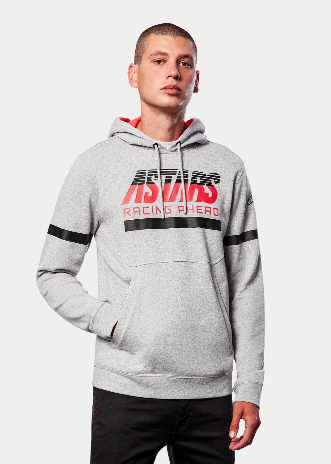 Alpinestars Club Hoodie, casual streetwear, gråmelerad med röd jerseyfodrad huva, ASTARS RACING AHEAD-grafik, svarta horisontella ränder på bröst och ärmar, motorsportinspirerad fleecehoodie