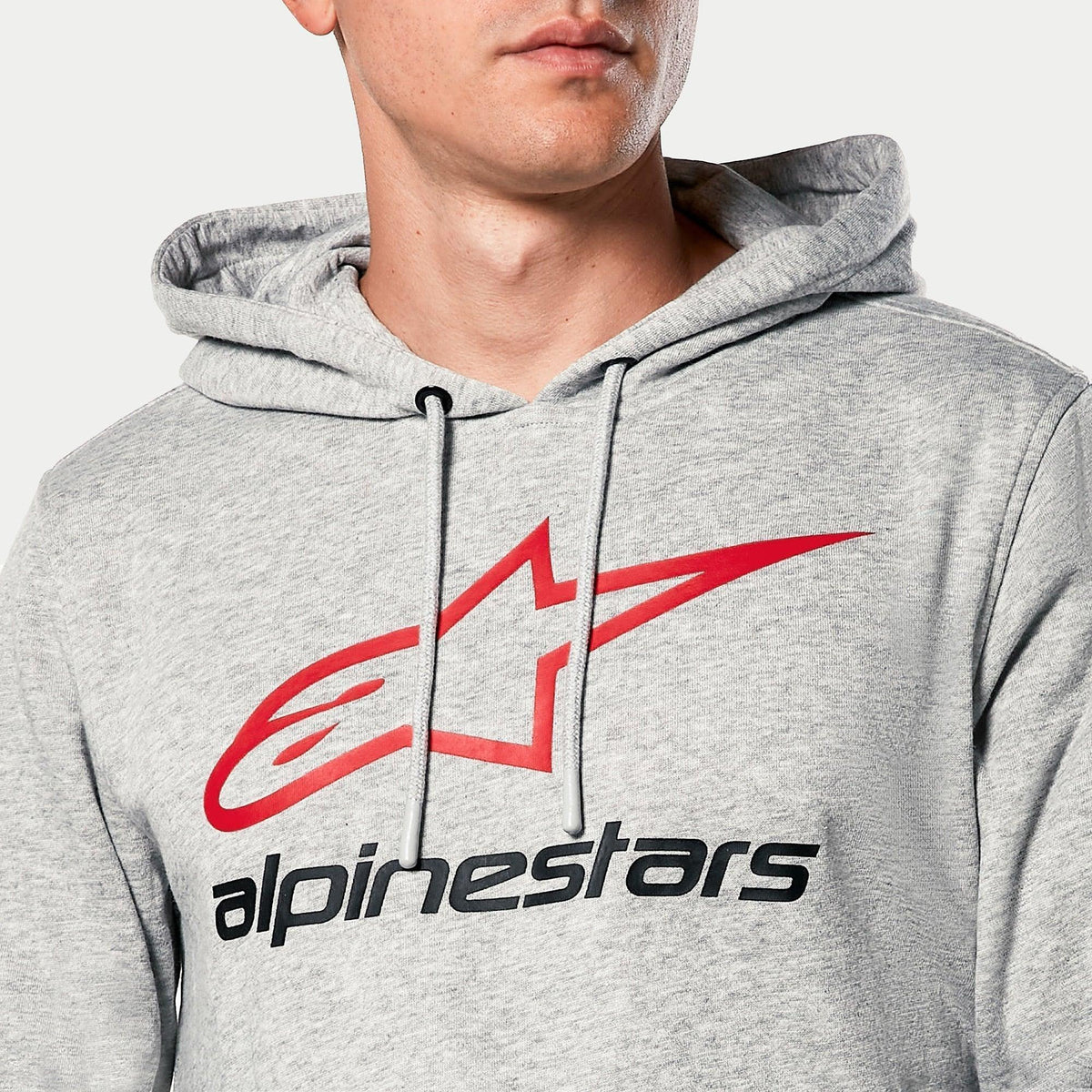 Alpinestars Always V3 Hoodie, gråmelerad, närbild på bröstet med röd stjärnlogotyp och svart Alpinestars-text, jerseyfodrad huva med grå dragsnören, avslappnad motorsport-streetwear