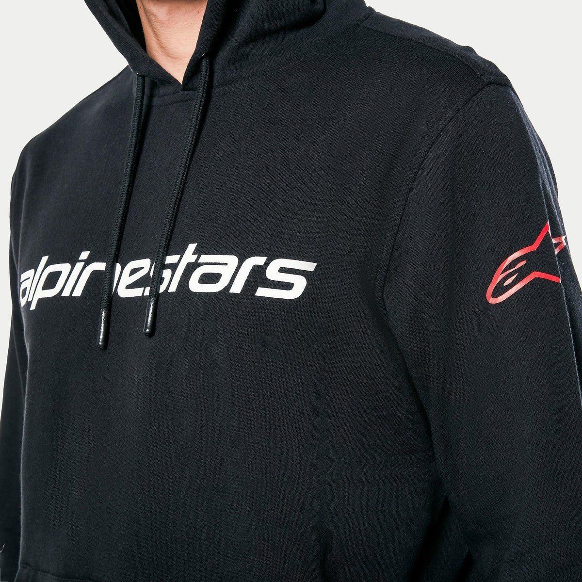 Alpinestars Linear Wordmark V3 Hoodie, svart, vitt Alpinestars-wordmark på bröstet och röd Ageless-logotyp på ärmen, vardaglig fleecehoodie i pullover-modell med huva och dragsko