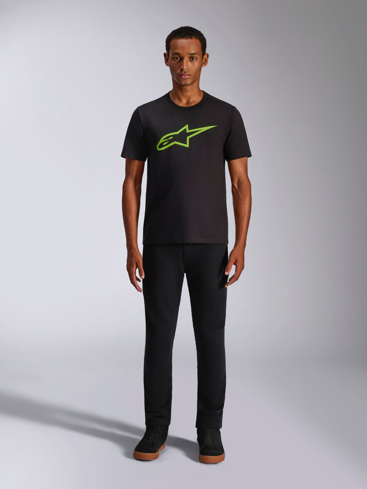 Alpinestars Ageless 2.0 CSF Tee, kortärmad t-shirt, svart med klargrön logotyp, bärs av modell med svarta byxor, avslappnad motorsportinspirerad design
