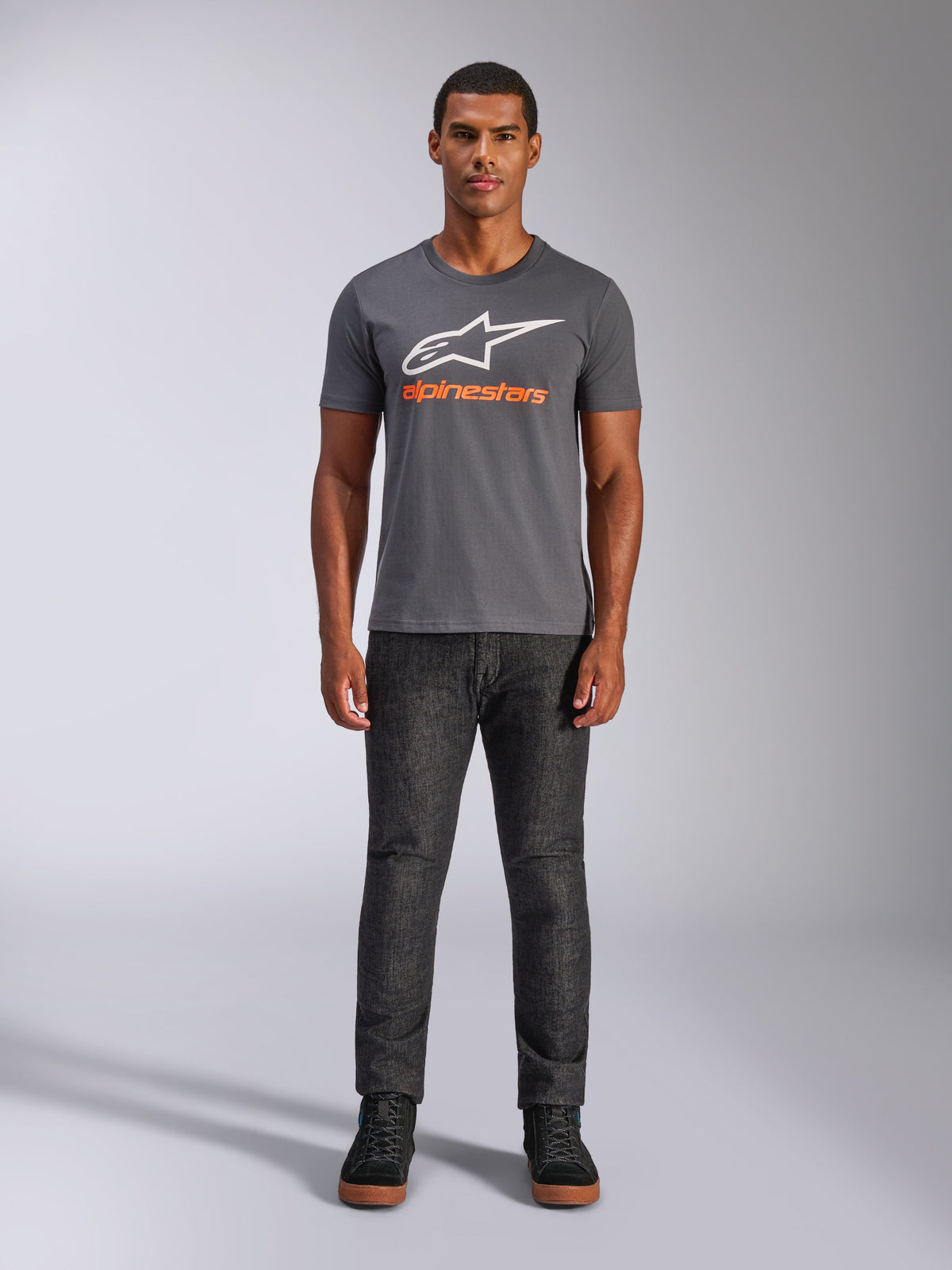 Alpinestars Always 2.0 CSF Tee, kortärmad t-shirt, mörkgrå med vit logotyp och orange text, bärs av modell med mörka jeans, casual motorsport-streetwear