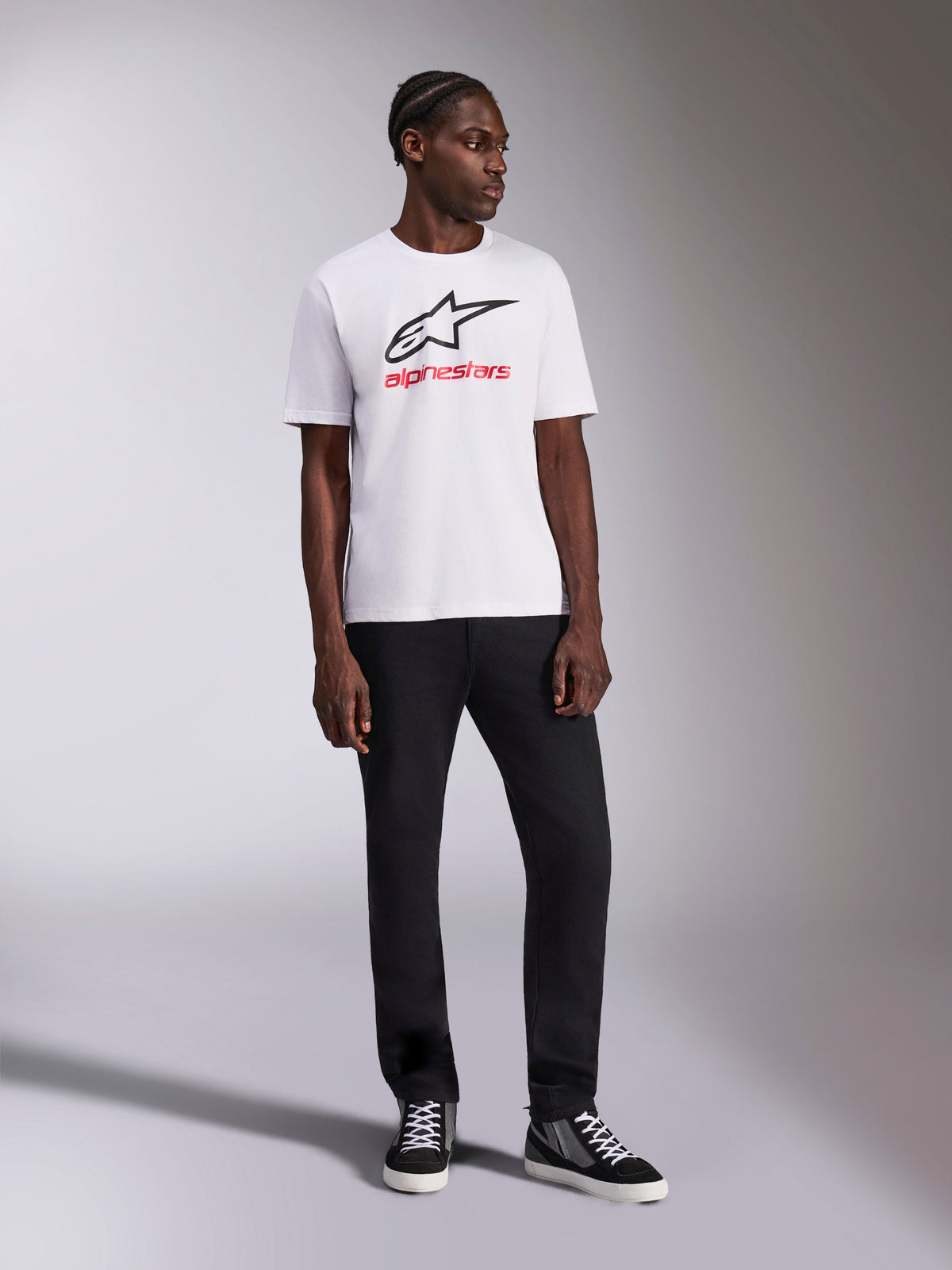 Alpinestars Always 2.0 CSF Tee, Short Sleeve T-Shirt, White, Black Astar Logo and Red Alpinestars Wordmark Graphic, worn by model with black pants and high-top sneakers, Casual Motorsport Sportswear