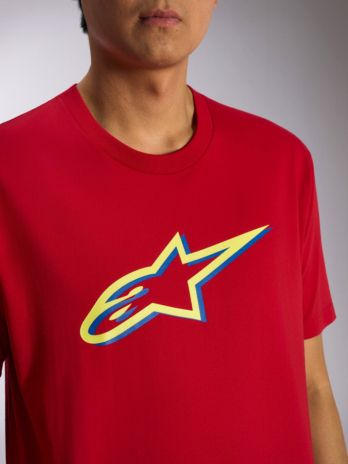 Alpinestars Ageless Shadow CSF Tee, Short Sleeve T-Shirt, Red, Yellow and Blue Ageless Shadow Logo Graphic, close-up view on model, casual motorsport streetwear