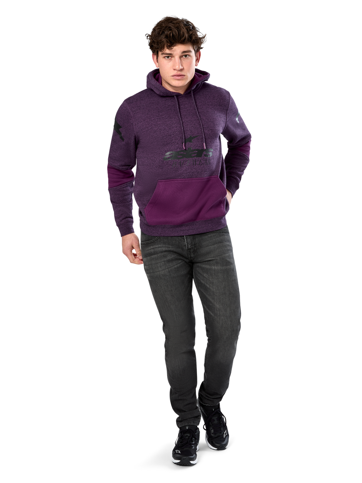Alpinestars Perpetuate Hoodie, casual streetwear, lila melerad fleece med mörklila färgblockering på kängurufickan och ärmarna, svart logotyp på bröstet, huva med dragsko, bärs av modell med mörkgrå jeans och svarta sneakers