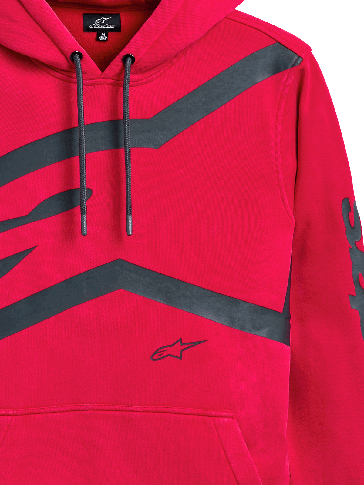 Alpinestars Unbound Hoodie, röd, närbild på bröstet och ärmen med stora mörkgrå grafiska logotyper, huva med dragsko, känguruficka, avslappnat motorsportinspirerat streetwear