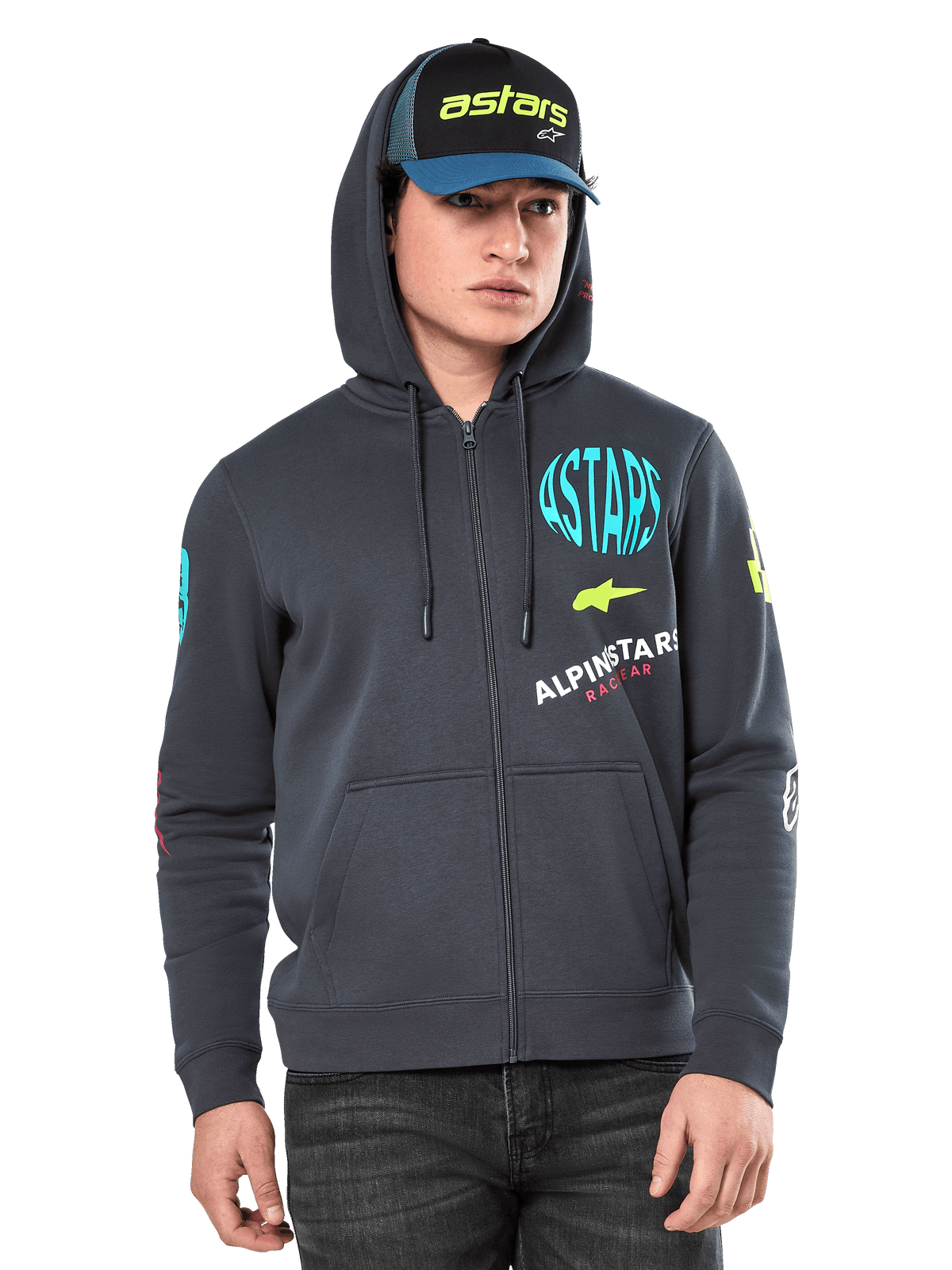 Alpinestars Variegate Huvtröja, fleecehoodie med dragkedja framtill, gunmetal-grå med flerfärgad logografik på bröst och ärmar, bärs av modell med matchande keps, vardaglig streetwear med kängurufickor och hellång dragkedja