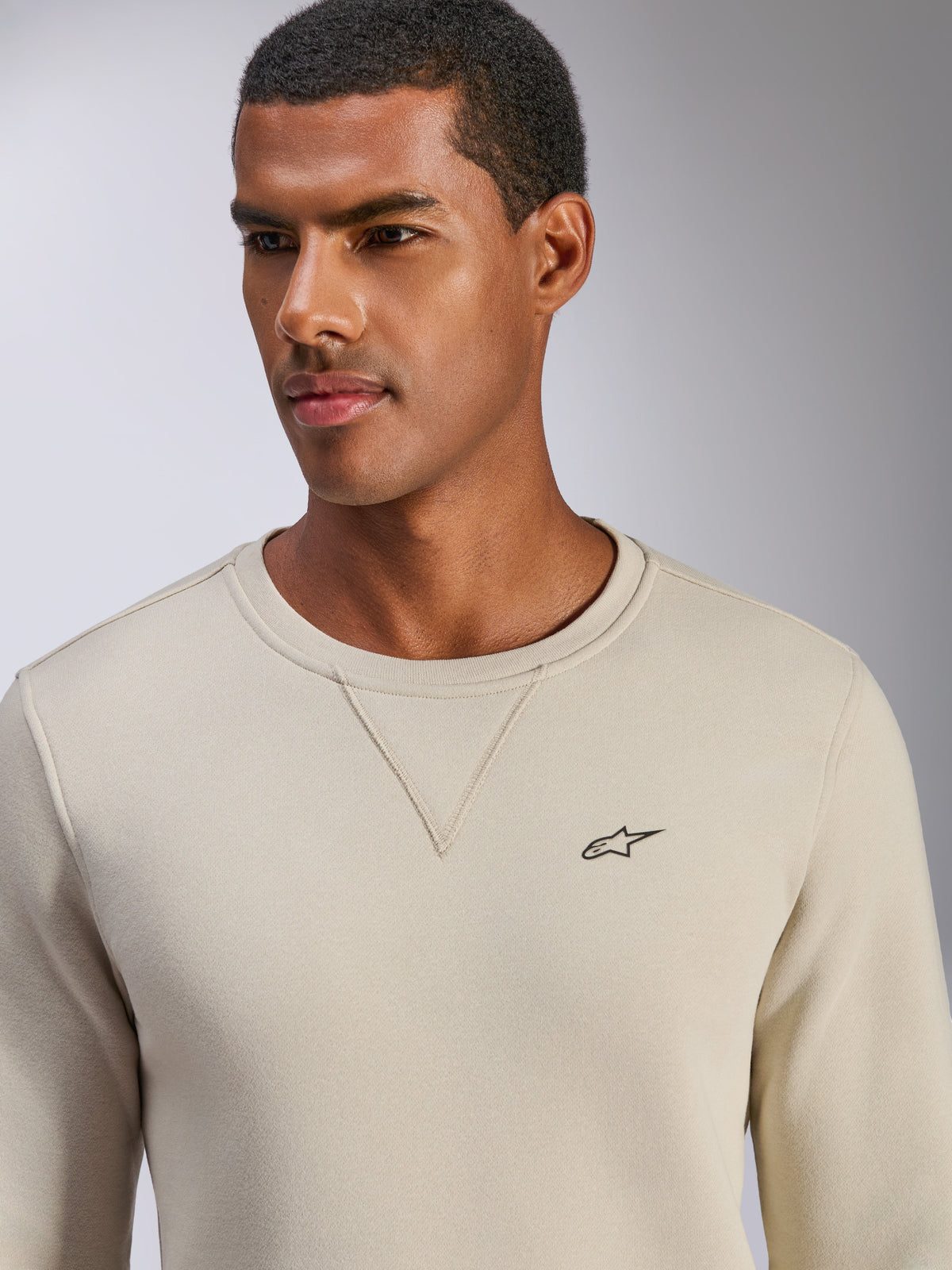 Alpinestars Positive Crew Sweatshirt, Off White, crewneck-tröja med liten svart stjärnlogotyp på bröstet, V-sömsdetalj vid halsringningen, avslappnade motorsportinspirerade livsstilskläder