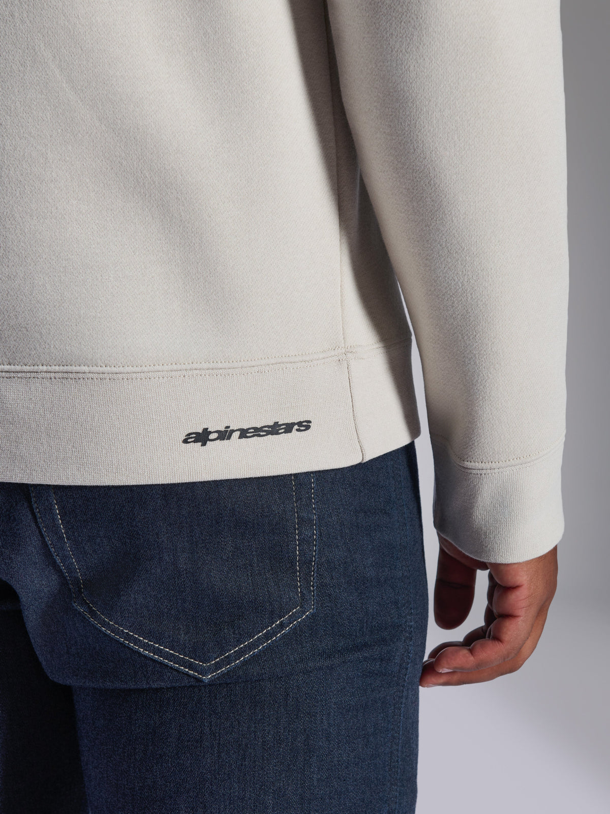 Alpinestars Positive Crew Sweatshirt, Off White, närbild på ribbad fåll och mudd, med en liten svart Alpinestars-logotyp, avslappnade motorsportinspirerade kläder