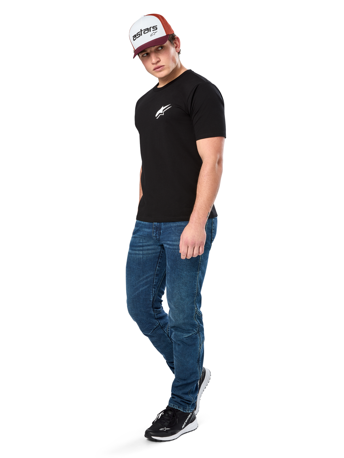 Alpinestars Formulate Csf Tee, Short Sleeve T-Shirt, Black with white Astars chest logo, worn by a model with blue jeans, a burgundy and white cap, and black sneakers, casual motorsport-inspired streetwear