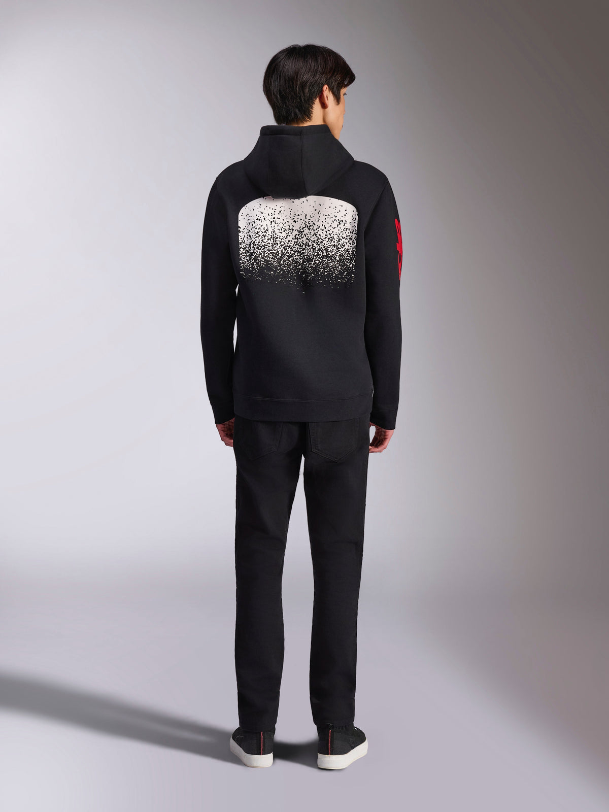 Alpinestars Obsessed Hoodie, sportkläder, svart med vit MX-graderad rygggrafik, röd ordlogotyp på ärmen, vy bakifrån, bärs med svarta byxor.