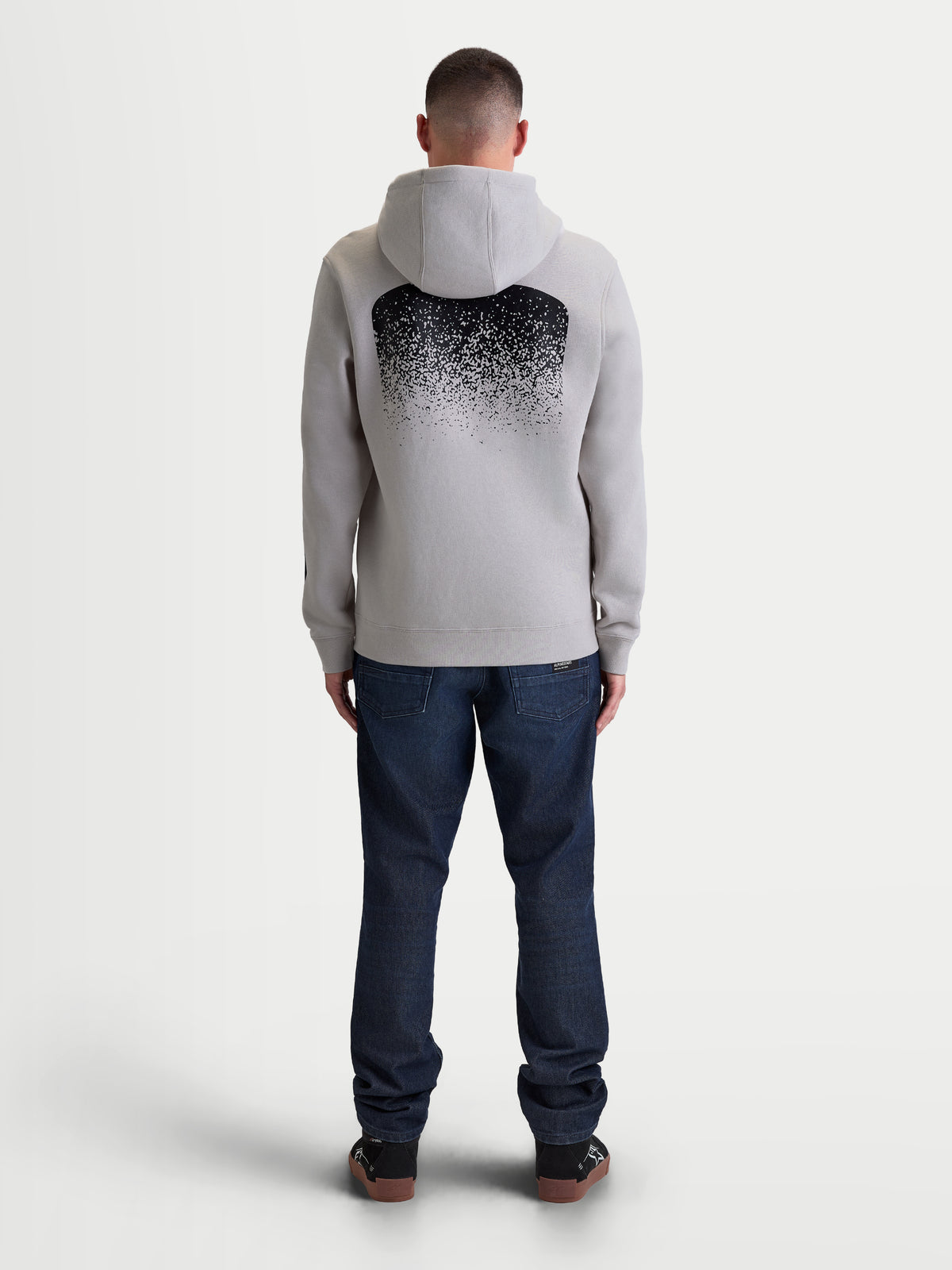 Alpinestars Obsessed huvtröja, herrhuvtröja i cementgrå och svart fleece, ryggvy med stor MX-inspirerad gradientgrafik, vardaglig motorsport-lifestyle med huva och ribbade avslut.