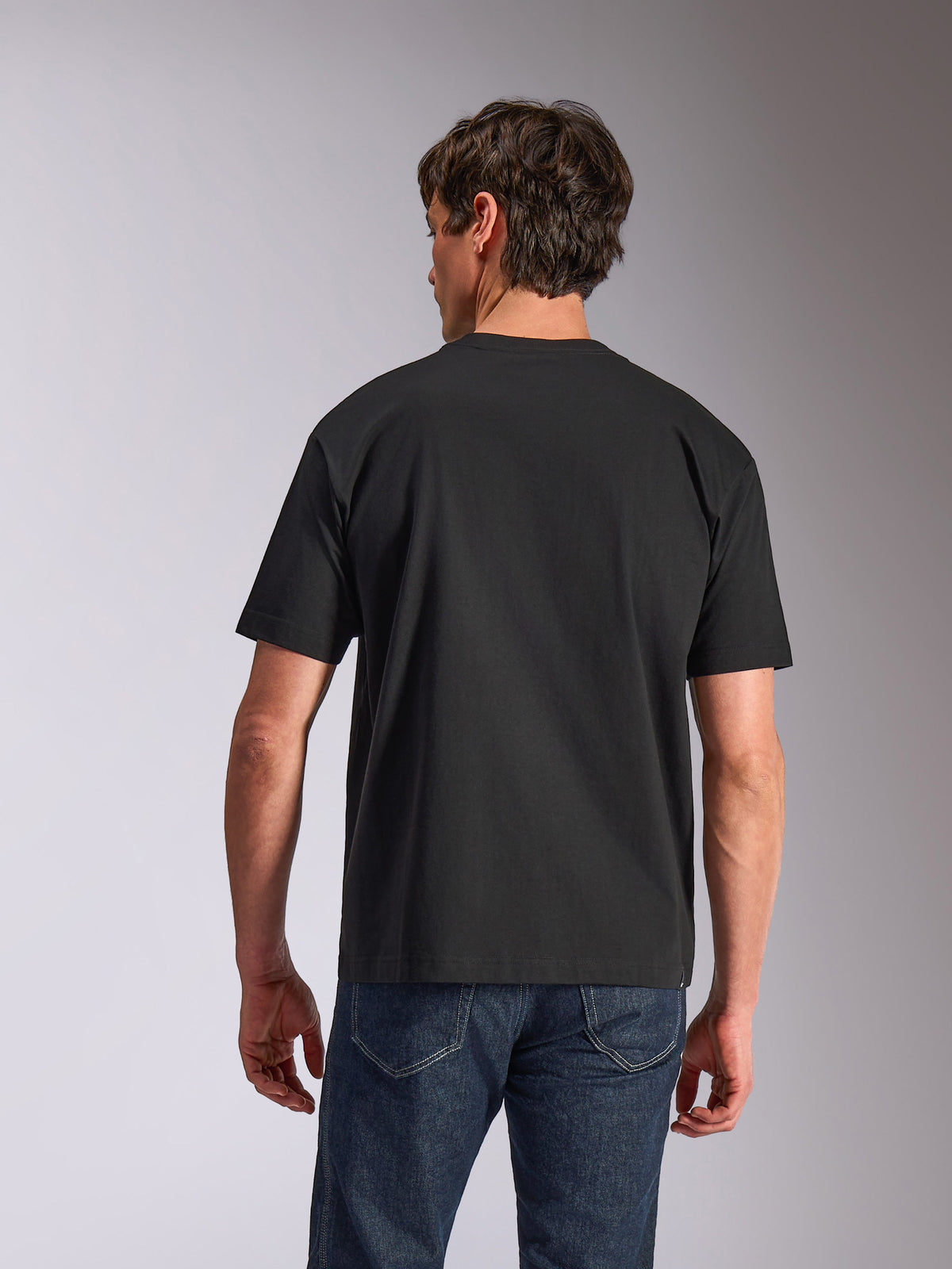 Alpinestars Aplomb Oversized CSF Tee, Short Sleeve T-Shirt, Black, back view, worn by model with blue jeans, relaxed fit casual sportswear