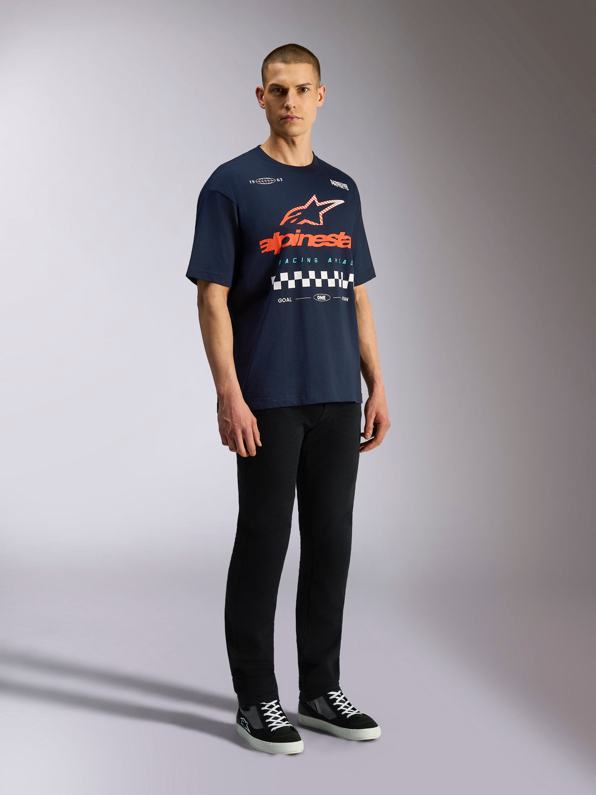 Alpinestars Aplomb Oversized CSF Tee, kortärmad t-shirt, marinblå, stor orange och vit Astars-logotyp med schackrutig grafik, avslappnat motorsportinspirerat streetwear