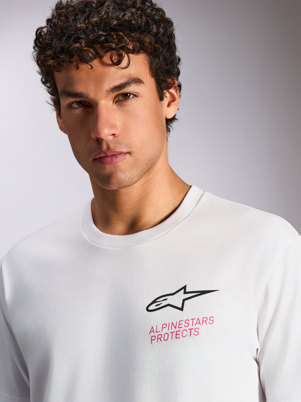 Alpinestars Pop Helmet CSF Tee, kortärmad t-shirt, vit, svart Astars-logotyp och rosa 'ALPINESTARS PROTECTS'-text på bröstet, casual motorsport-streetwear