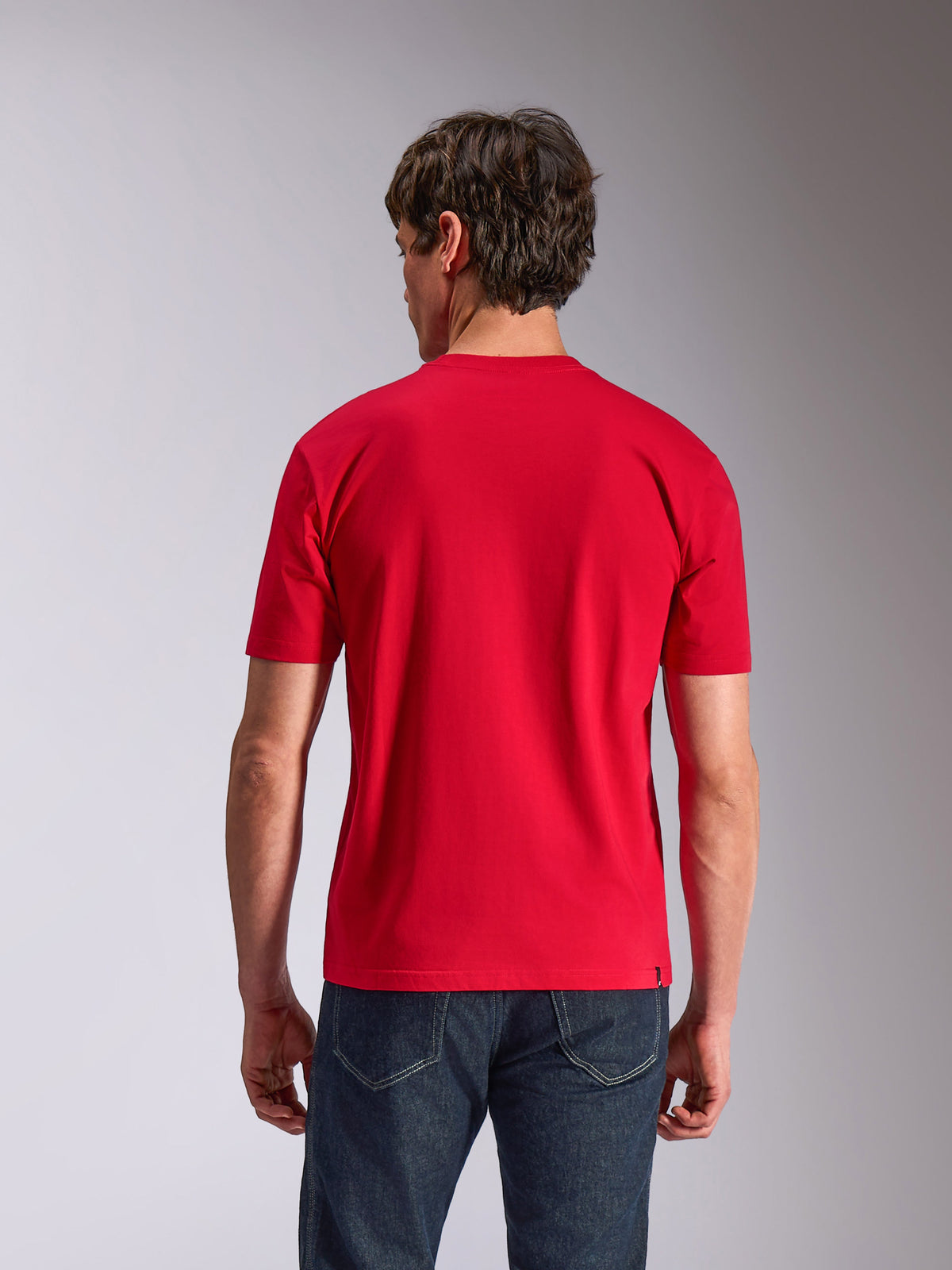 Alpinestars Authority CSF Tee, kortärmad t-shirt, röd, sedd bakifrån på modell i mörka jeans, avslappnad motorsport-streetwear