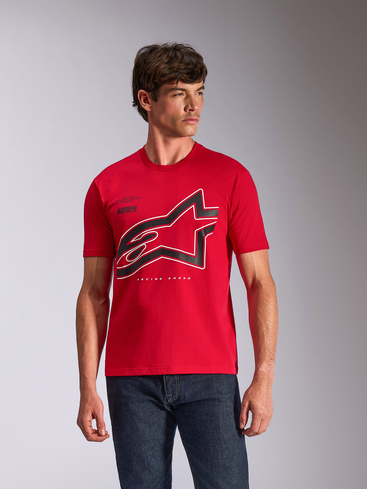 Alpinestars Authority CSF Tee, kortärmad t-shirt, röd, stor svart och vit konturerad Astars-logotyp på bröstet, bärs av en manlig modell med mörkblå jeans, avslappnad motorsport-inspirerad streetwear
