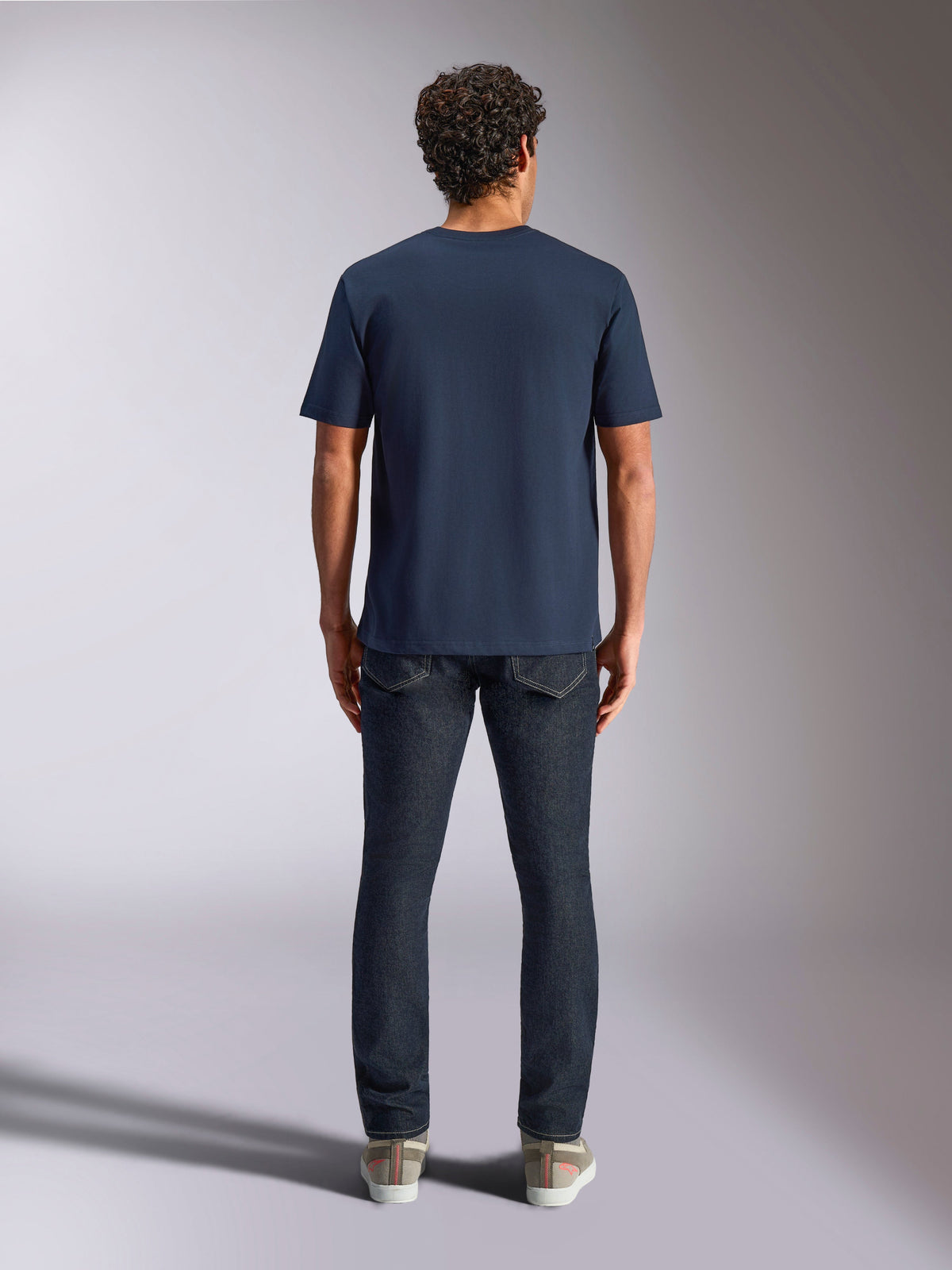 Alpinestars Trifecta CSF Tee, kortärmad t-shirt, mörkblå, sedd bakifrån på modell, kombinerad med mörka jeans och sneakers, vardaglig motorsport-streetwear