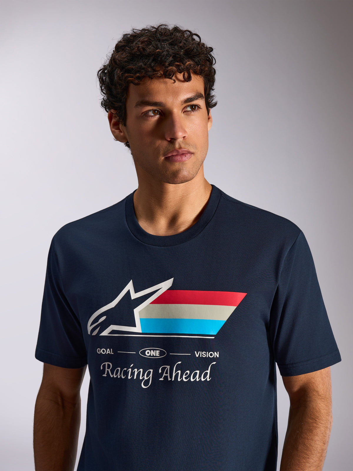 Alpinestars Trifecta CSF Tee, kortärmad t-shirt, marinblå, vit Astars-logotyp med trefärgade ränder och texten "Racing Ahead", livsstilsbild i avslappnad motorsportstil