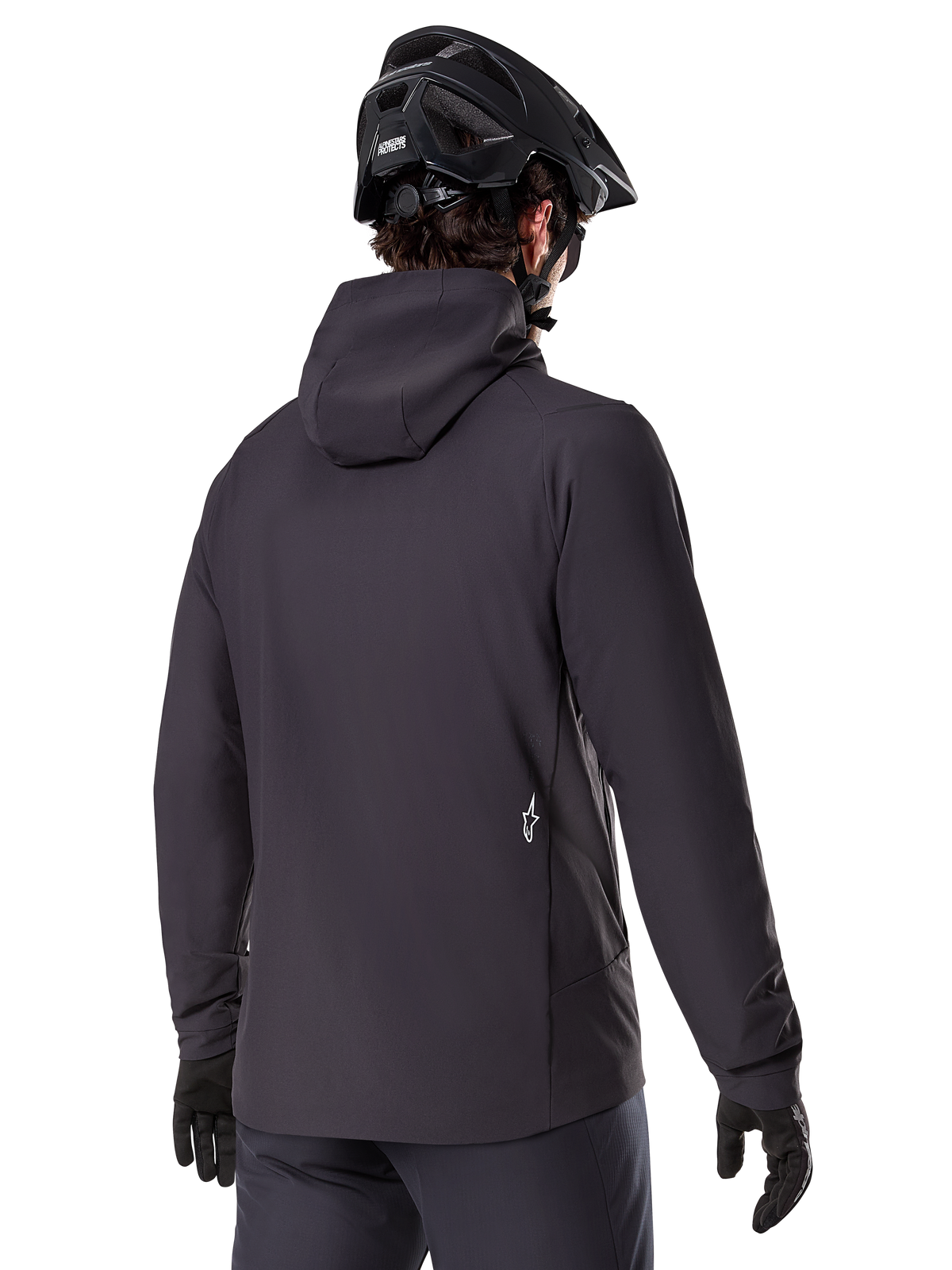 Alpinestars A-Dura Thermal Jacket, svart, vy bakifrån, bärs med en svart mountainbikehjälm och handskar, har en liten vit Astars-logotyp på nedre delen av ryggen, lätt isolerad cykeljacka