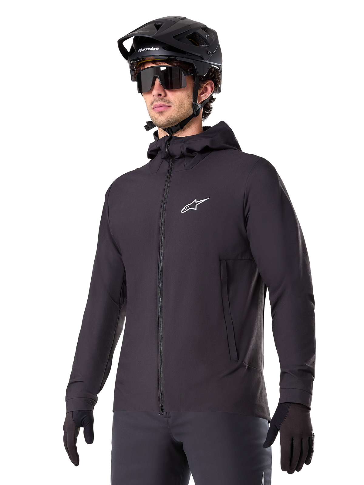 Alpinestars A-Dura Thermal Jacket, svart cykeljacka, design med huva och dragkedja framtill, vit stjärnlogotyp på bröstet, bärs med svart mountainbikehjälm och handskar, sportig funktionsutrustning för terrängcykling i kallt väder