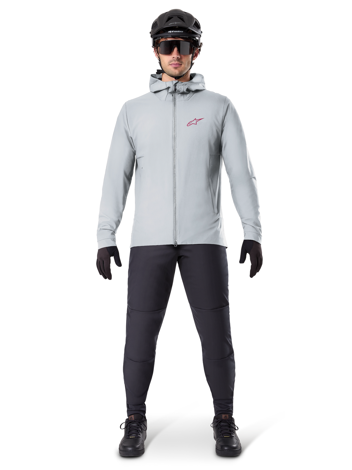 Alpinestars A-Dura Thermal Jacka, titaniumgrå, cykeljacka bärs med svarta mountainbikebyxor, handskar och hjälm, med en liten röd stjärnlogotyp på bröstet och hel dragkedja fram, lätt isolerad utrustning för terrängkörning