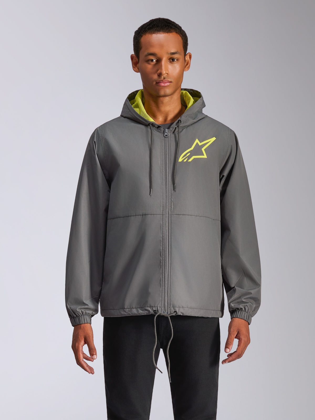 Alpinestars Speeder Chromium Windbreak Jacket, charcoal gray hooded windbreaker with hi-vis yellow star logo, lime green hood interior, elastic cuffs, adjustable drawstrings, front zipper closure, casual motorsport style