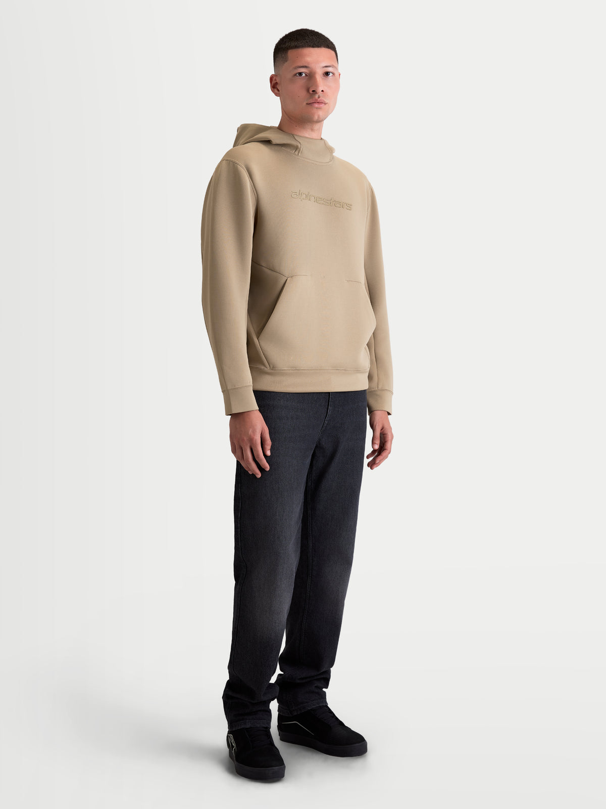 Alpinestars Datrix huvtröja, brun premium huvtröja för herr i dubbelvävd fleece, med tonala logotyper, meshfodrad huva och framficka med dartdetalj, visas på modell för en motorsportinspirerad look.