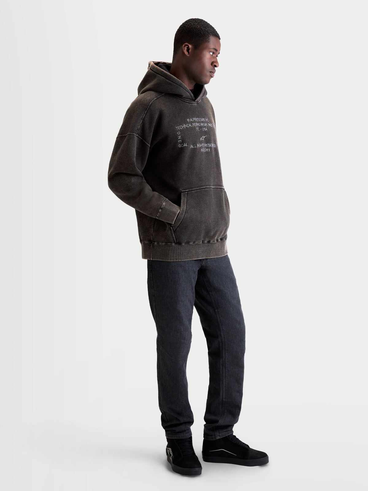 Alpinestars Infinite Washed Oversize huvtröja, avslappnad sportswear för herrar, svart med snötvättad finish, vit broderad logotypgrafik på bröstet och känguruficka.