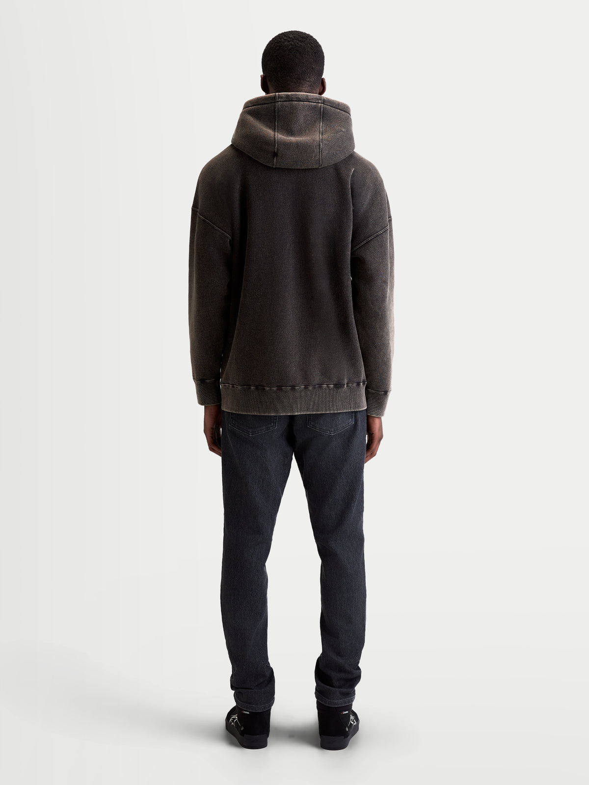 Alpinestars Infinite Washed Oversize huvtröja, avslappnad sporttröja i unisexmodell, svart med mjuk fleece och snötvättad finish. Vy bakifrån som visar den avslappnade passformen, huvdetaljer och ribbad fåll.