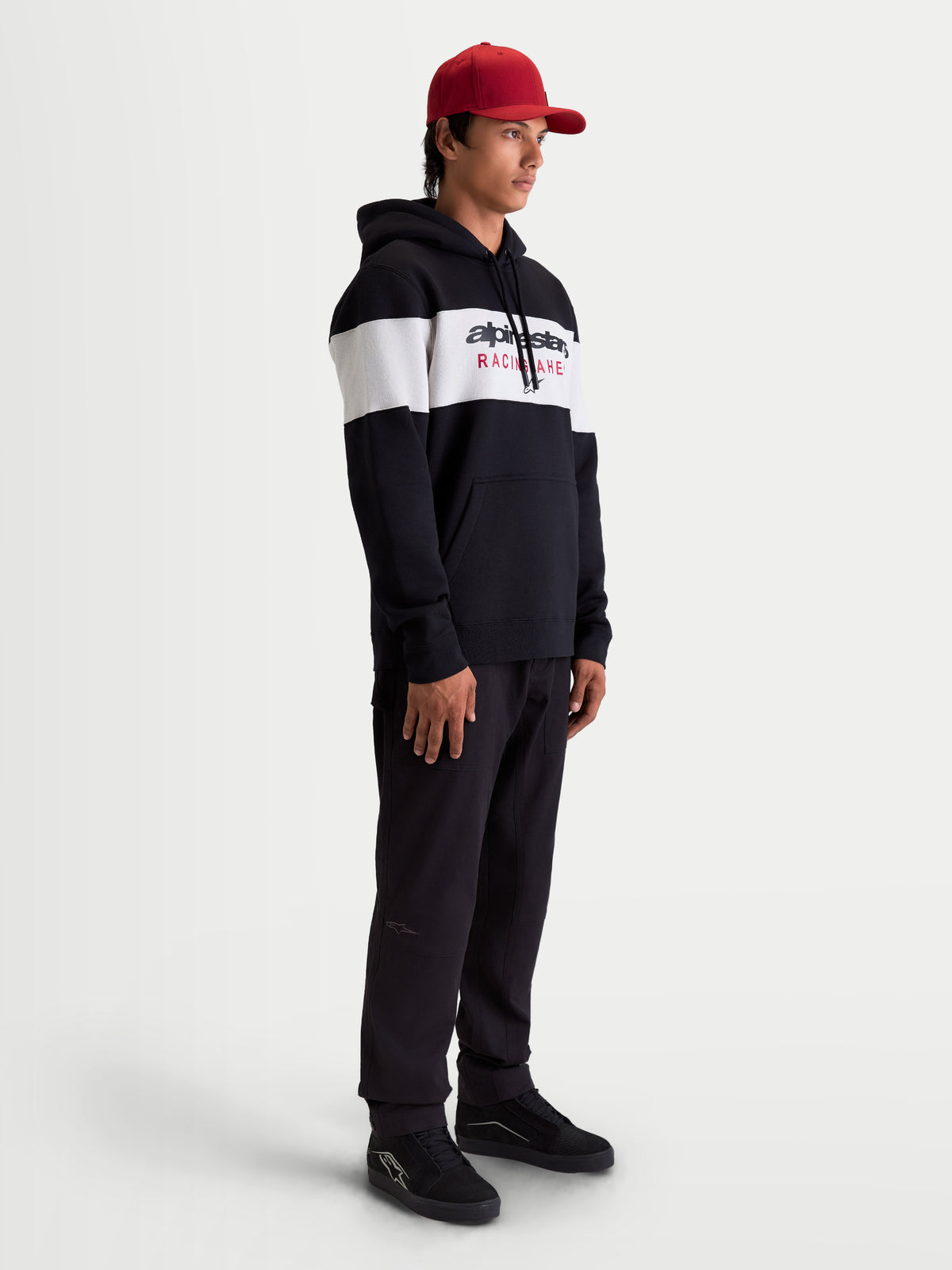Alpinestars Cubic huvtröja, herrhuvtröja i fleece för fritidsbruk, svart och vit färgblockerad design med Alpinestars logotyp på bröstet, mjuk bomullsblandning, lifestyle-vy på modell.