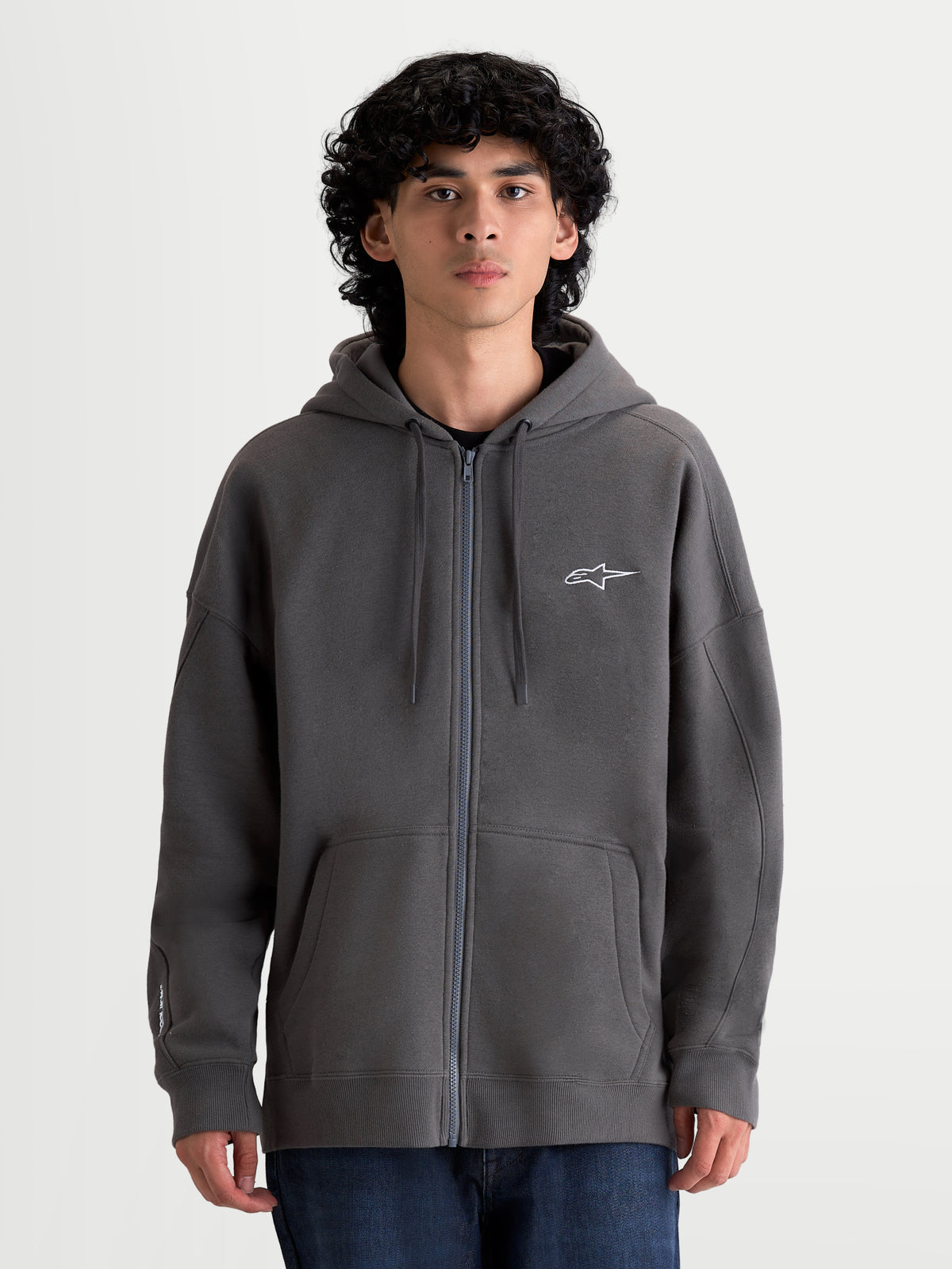 Alpinestars Entity Oversized huvtröja, mörkgrå fleecehuvtröja med dragkedja, broderad Astars-logotyp på bröstet, känguruficka och oversized passform, tillverkad av bomull och återvunnen polyester, avslappnad motorsportstil för vardagsbruk.