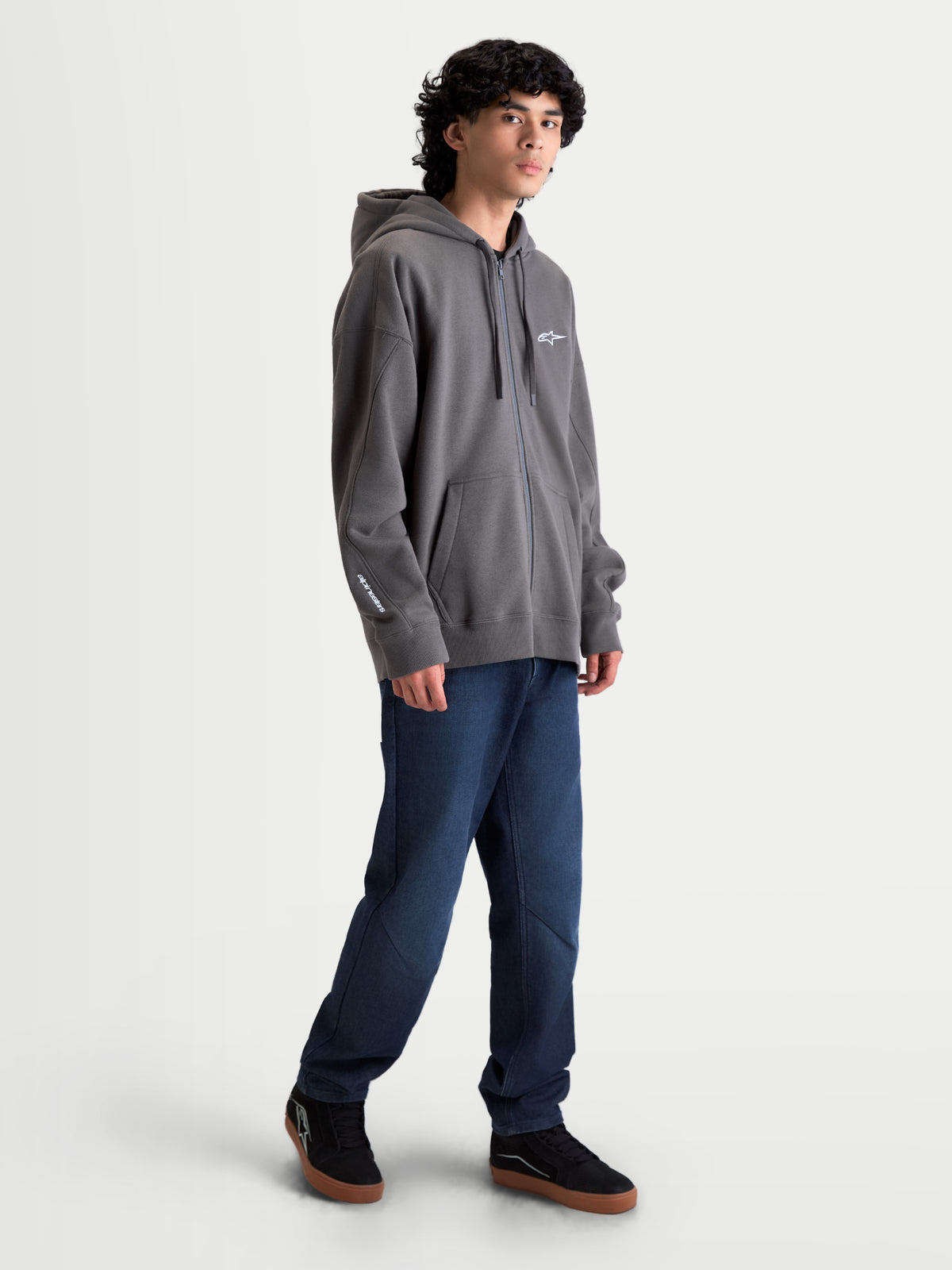 Alpinestars Entity Oversized huvtröja, mörkgrå zip-fleece för motorsport-lifestyle, herrmodell med oversized passform, vit broderad logotyp på bröstet och ärmen, kängurufickor och huva.