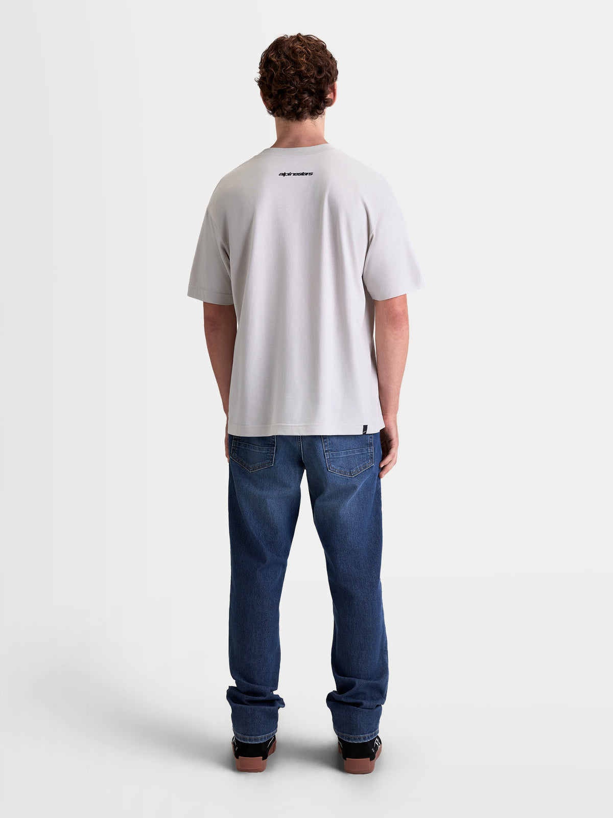 Alpinestars Prelude Oversized CSF t-shirt, kortärmad sportswear-t-shirt för herr, grå, sedd bakifrån på modell med en liten svart Alpinestars-logotyp, avslappnad oversized passform, premium bomulls- och polyesterblandning.