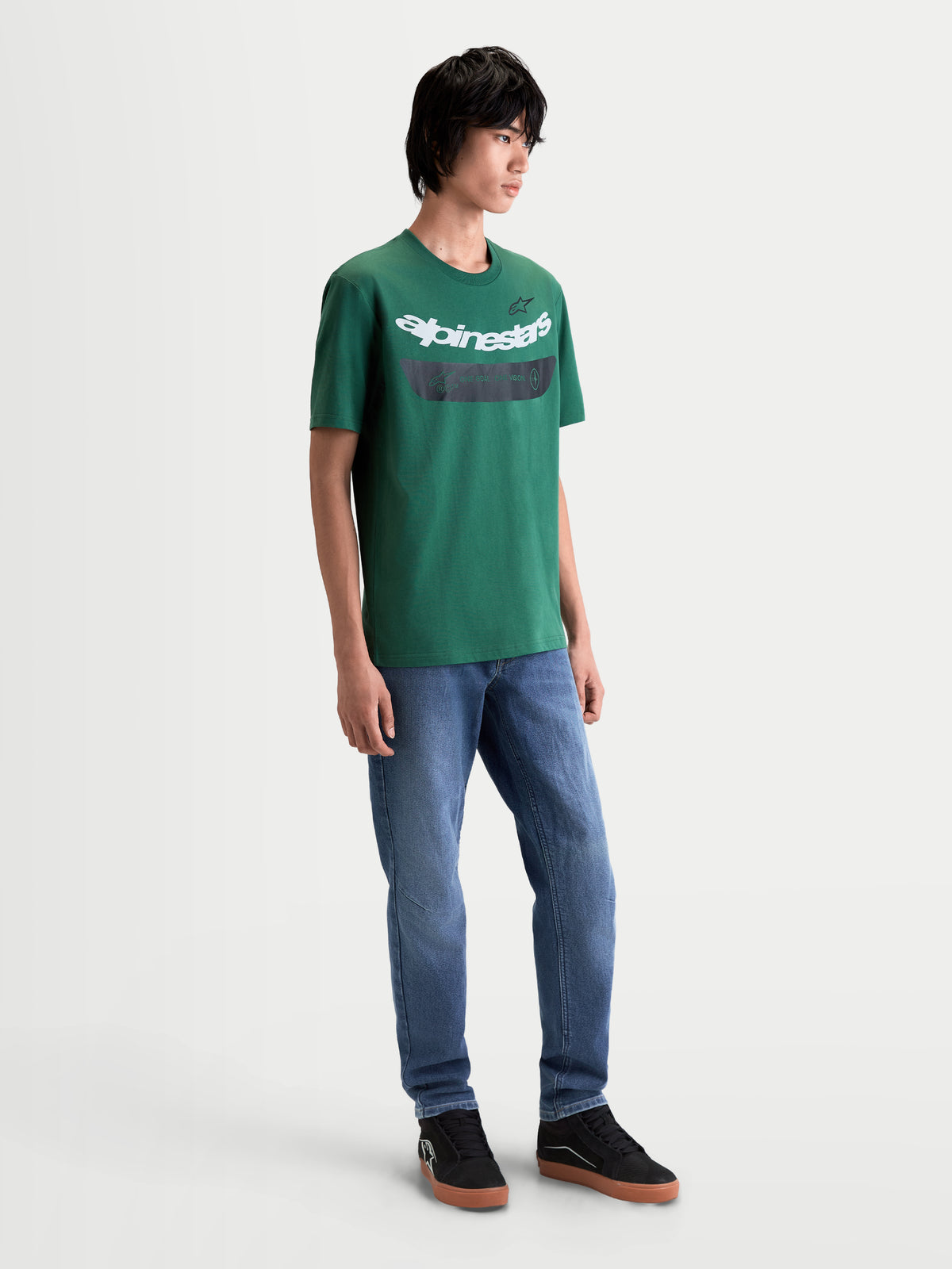 Alpinestars Singular CSF T-shirt, kortärmad t-shirt för herrar, grön med vit böjd logotypgrafik framtill, mjuk bomulls- och polyesterblandning, bekväm motorsport-streetwear buren av modell.