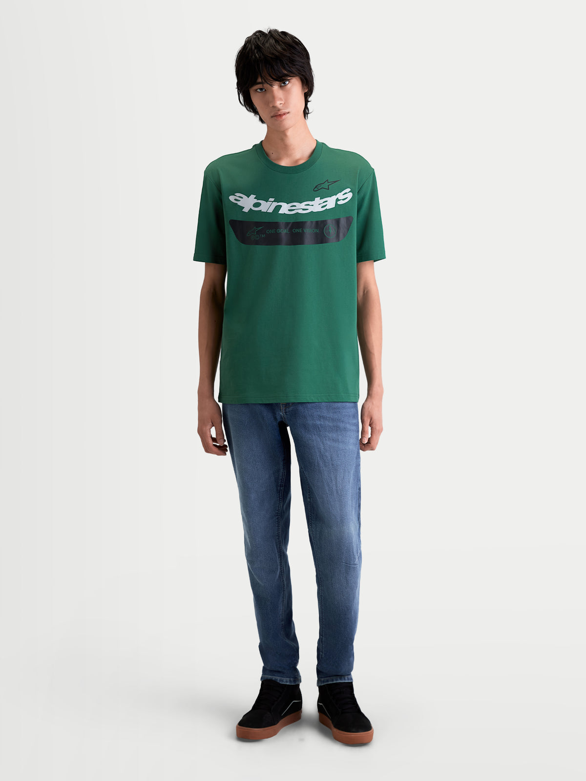 Alpinestars Singular CSF t-shirt, grön kortärmad t-shirt med vit böjd Astars-logotyp och svart bröstdetalj med texten 'One Goal. One Vision.', frontvy på modell, bekväm bomulls- och polyesterblandning, motorsport-streetwear
