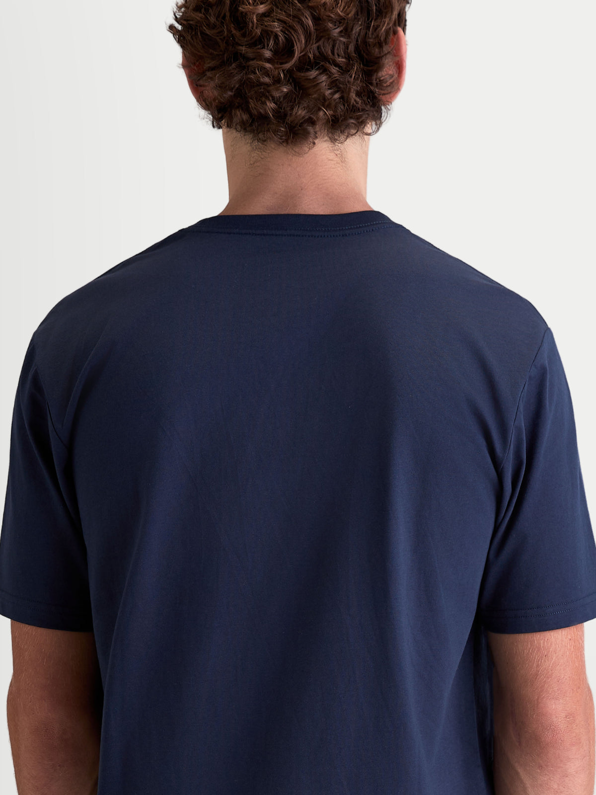 Alpinestars Cypress CSF T-Shirt, mörkblå kortärmad t-shirt för herrar och damer, ryggvy på modell, premium bomulls- och polyesterblandning för vardagskomfort