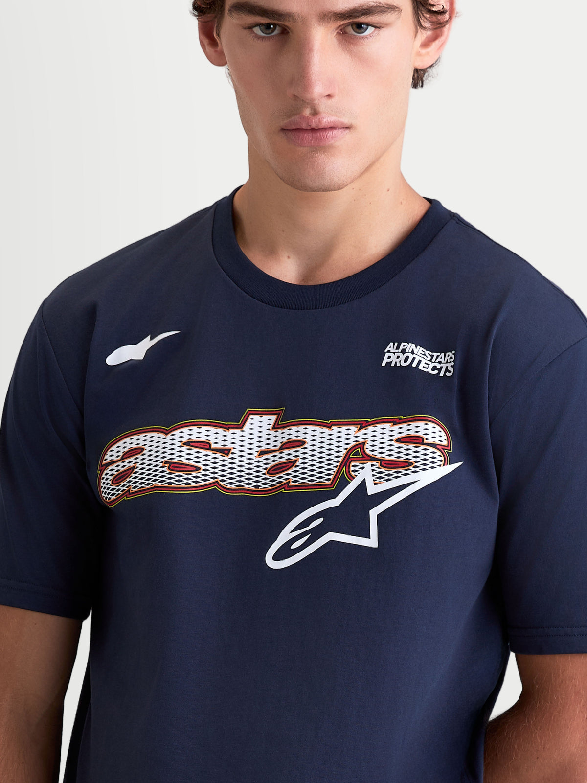 Alpinestars Cypress CSF t-shirt, kortärmad sportswear t-shirt för herrar, mörkblå och vit, med meshfylld Astars word-grafik och logotyp på bröstet, Alpinestars Protects-text, bomulls- och polyesterblandning, närbild på modell.