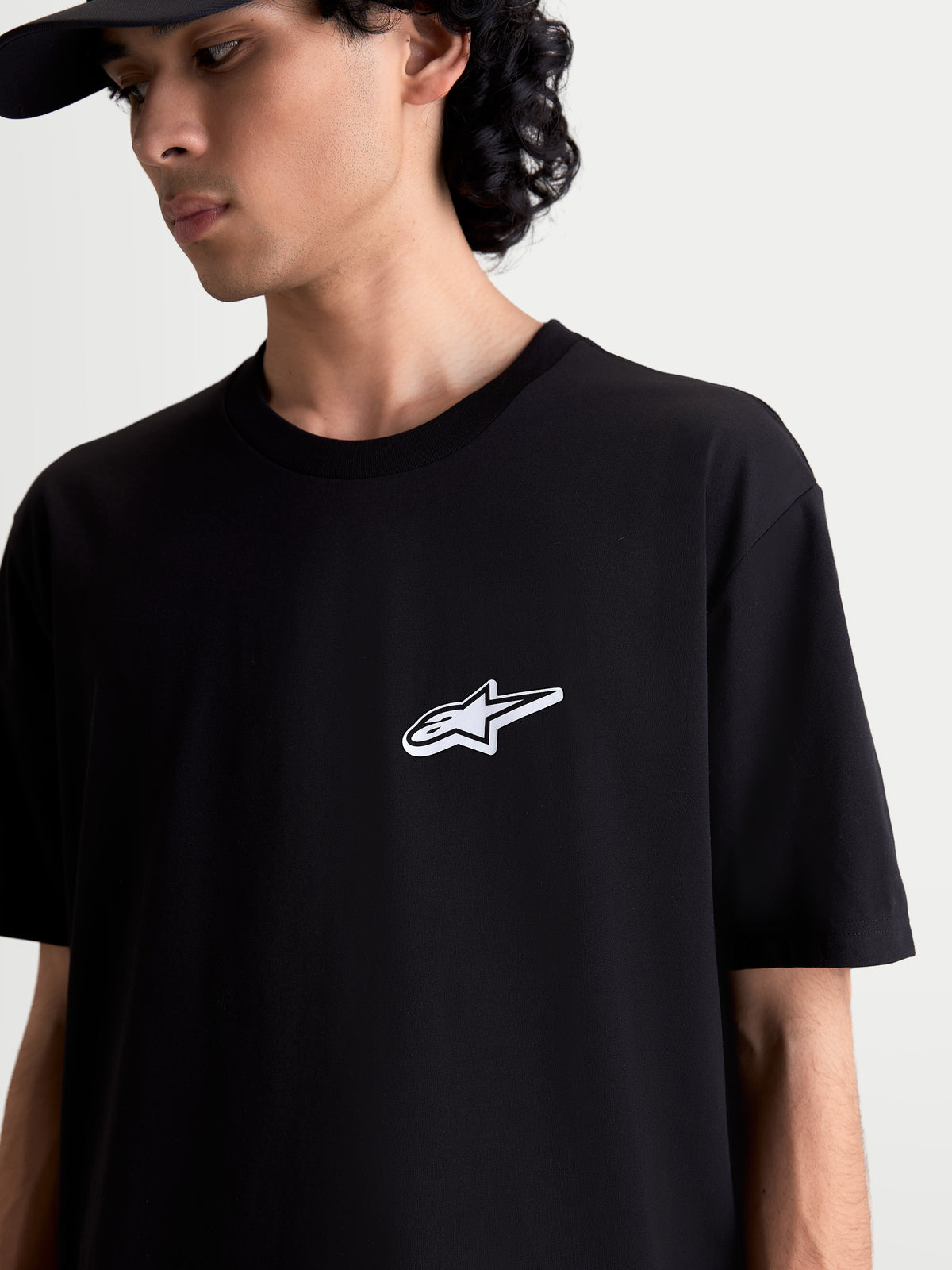 Alpinestars Meteor CSF t-shirt, svart kortärmad sportswear t-shirt med Astars-logotyp på bröstet, på modell, mjuk bomulls- och polyesterblandning, motorsport-inspirerad design.
