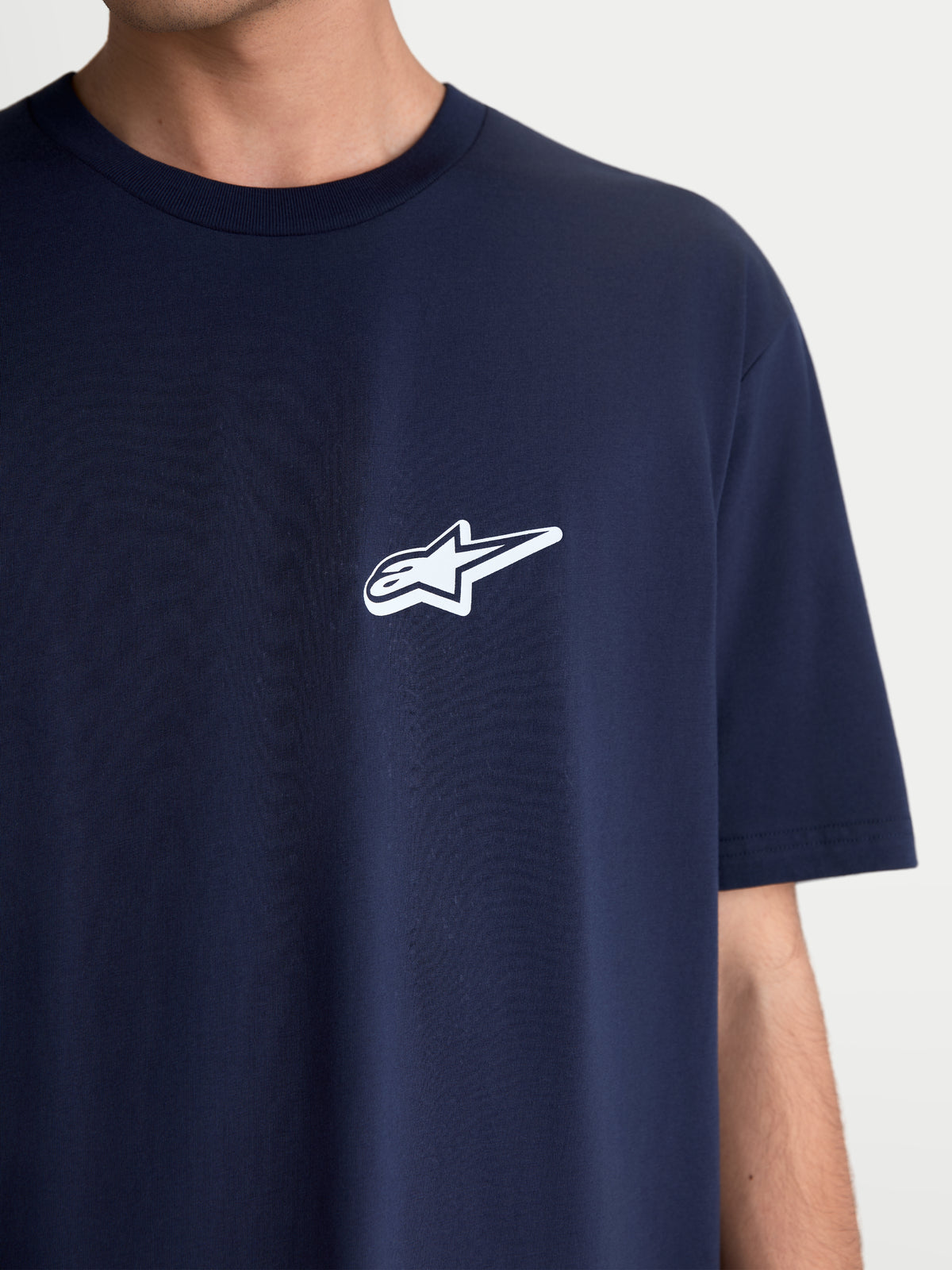 Alpinestars Meteor CSF t-shirt, kortärmad sportswear t-shirt, mörkblå med vit Astars-logotyp på bröstet, avslappnad motorsport-apparel, mjuk bomulls- och polyesterblandning, närbild på modell.
