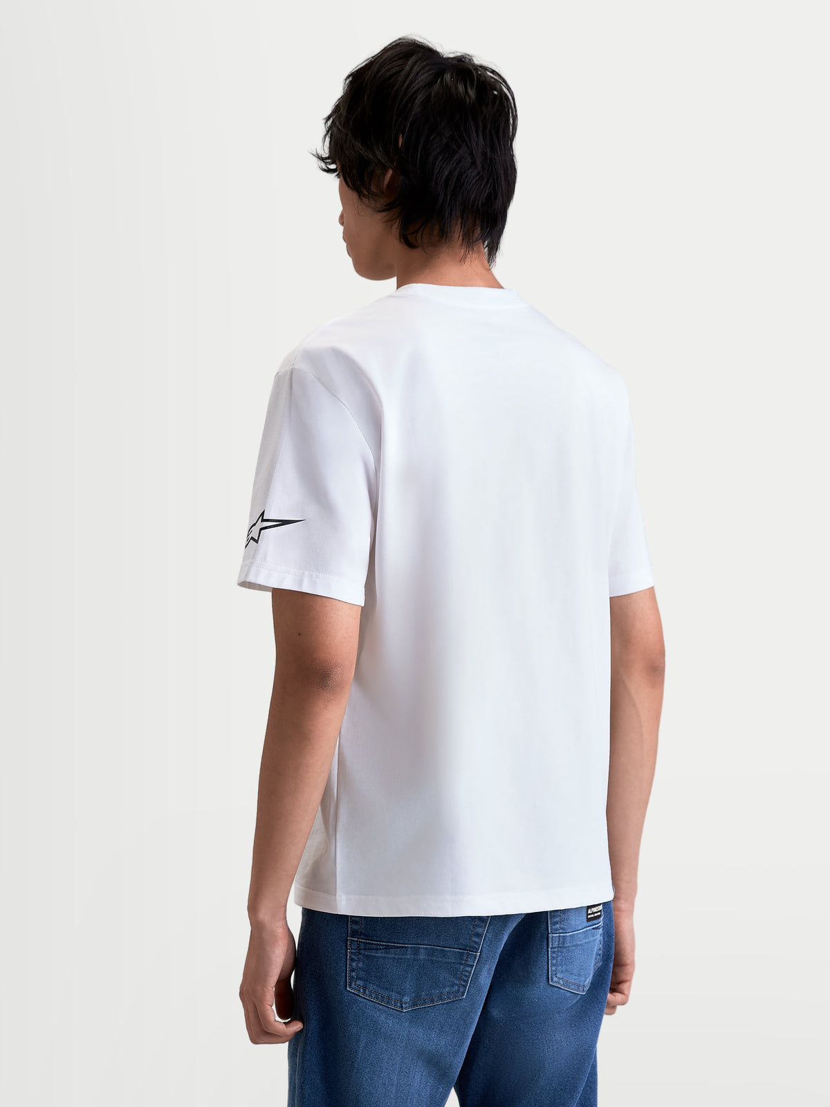 Alpinestars Race Wordmark CSF t-shirt, kortärmad t-shirt, vit och svart, 60/40 bomulls- och polyesterblandning, ryggvy på modell som visar Ageless-logotypen på ärmen.