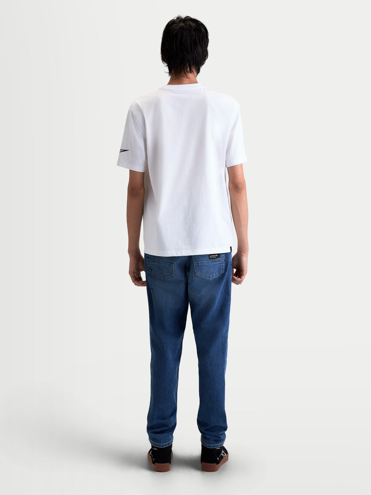 Alpinestars Race Wordmark CSF T-shirt, vit kortärmad sporttröja sedd bakifrån på modell, svart Ageless-logotyp på ärmen, mjuk bomulls- och polyesterblandning, livsstilskläder