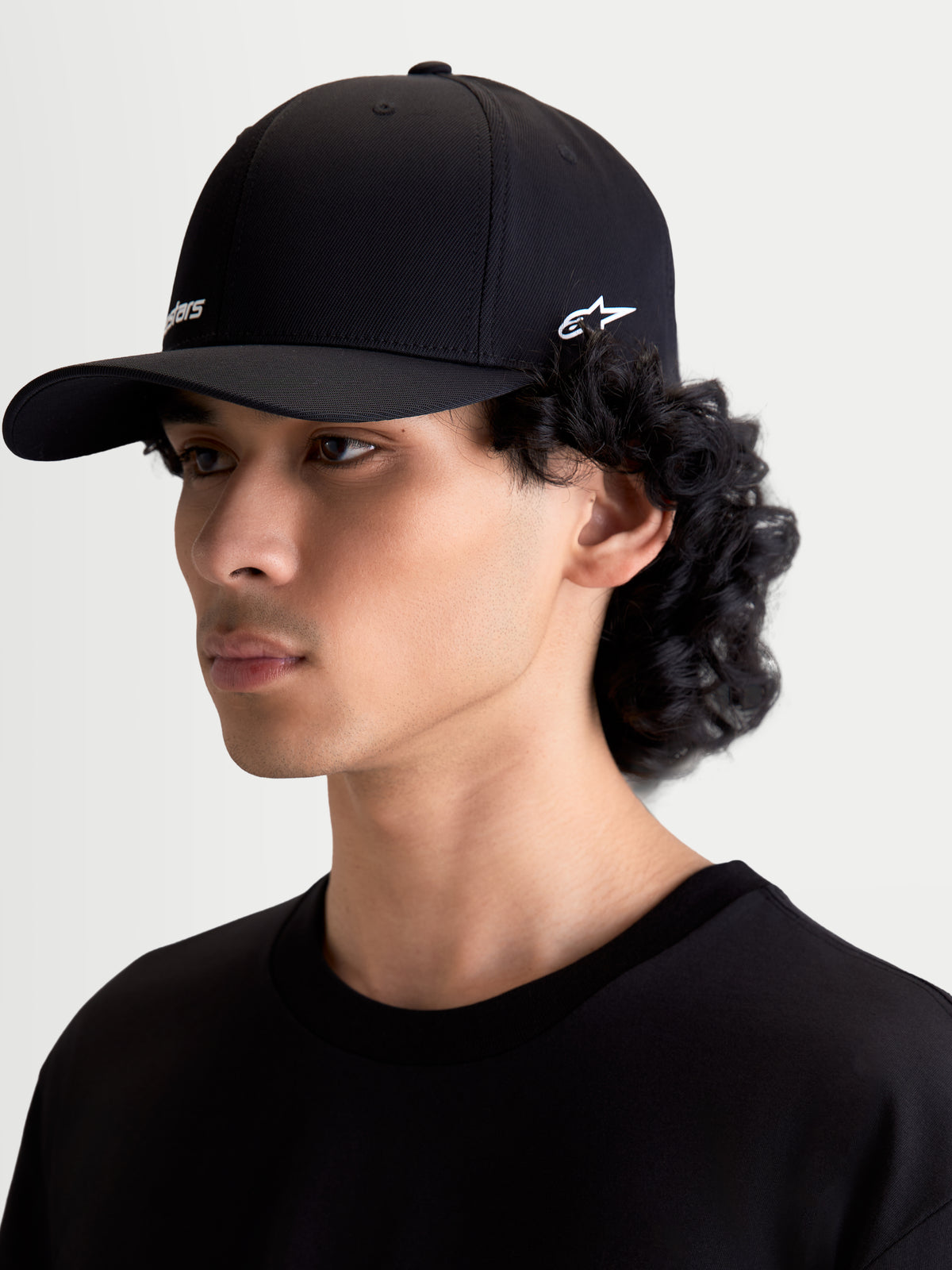 Alpinestars Points keps, sportkeps för vardagsbruk med böjd skärm, svart med vita HD-logotyper, tillverkad i lätt nylon tactel, flexrygg för bekväm passform, sidovy på modell, avslappnad motorsport-livsstil.