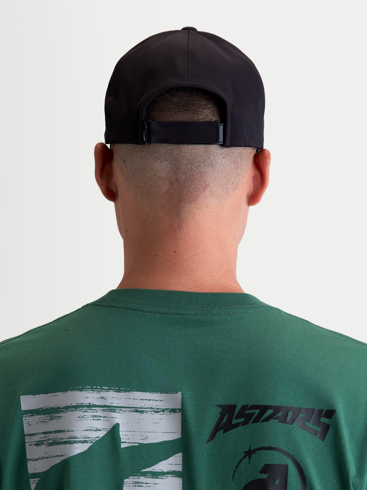 Alpinestars Algo Perf Adjustable keps, svart motorsportinspirerad sportkeps, unisex, baksida på modell som visar den justerbara stängningen och teknisk textilkonstruktion.