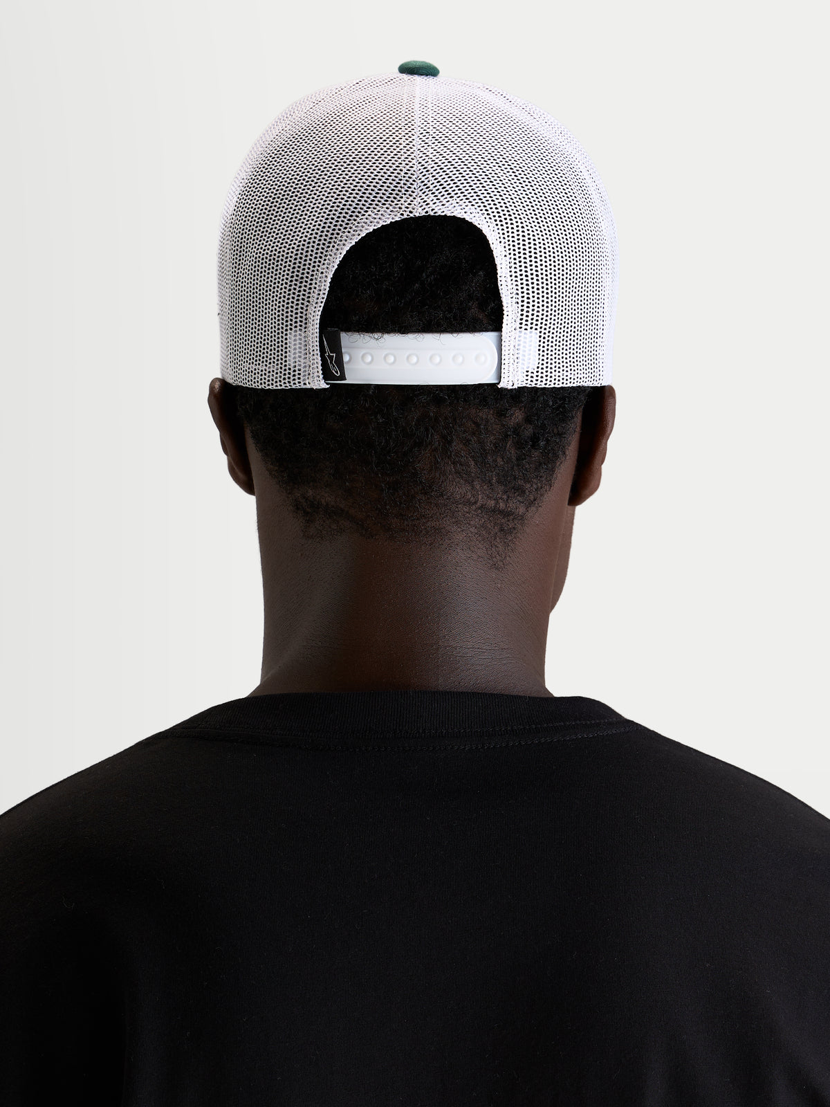 Alpinestars Baron Trucker keps, vit och grön vardagskeps med meshpaneler, vy bakifrån som visar justerbar snapback-stängning på modell