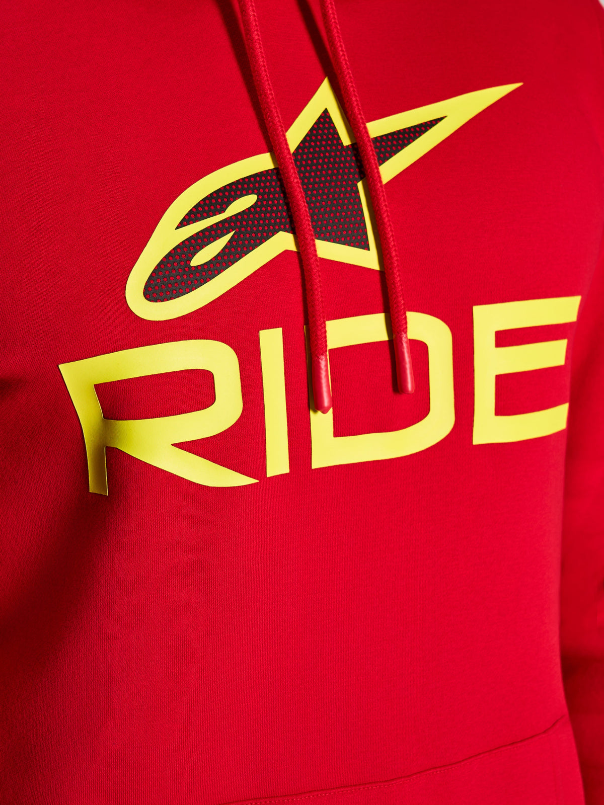 Alpinestars Ride V3 Hoodie, närbild på bröstgrafik, röd med Hi-Vis-gul RIDE-text och svart perforerad stjärnlogotyp, röda dragskor med doppade ändar, premiumfleece, casual streetwear