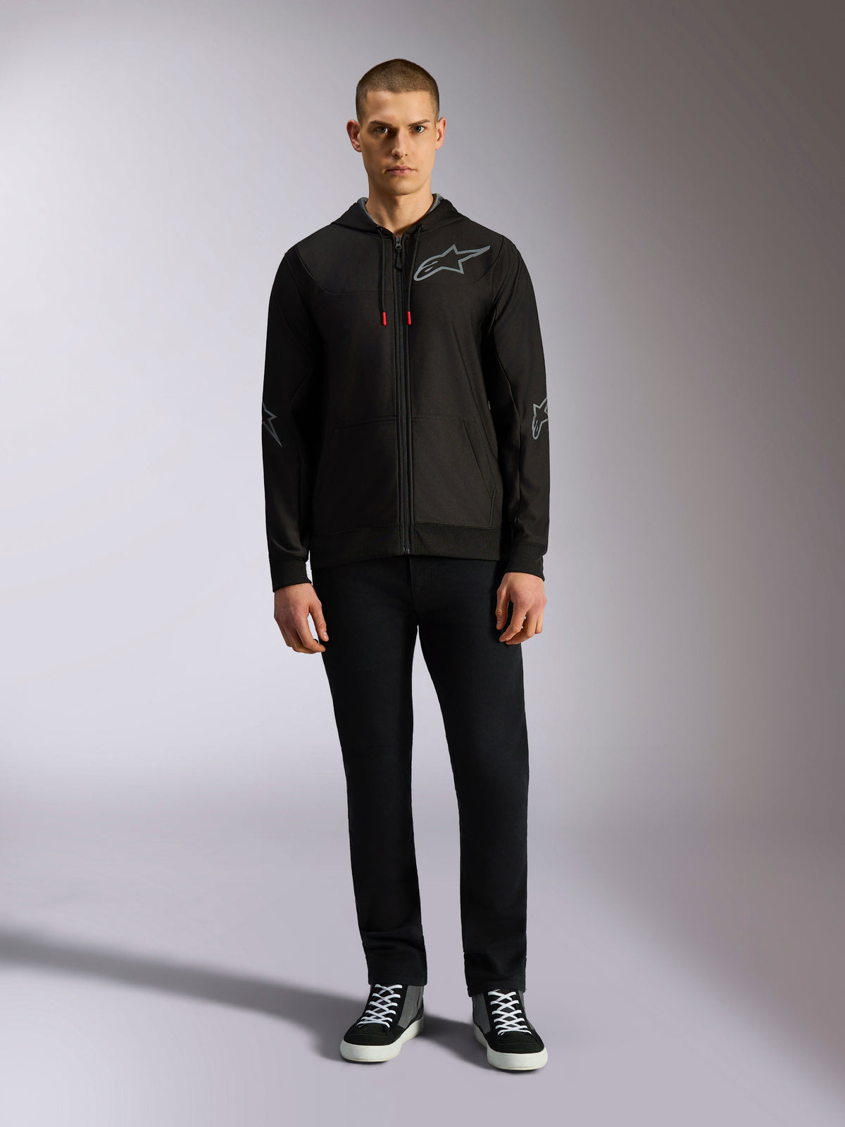 Alpinestars Sessions V3 Hoodie, fleecehuvtröja med dragkedja, svart med grå Astars-logotyp på bröstet och ärmarna, dragsko med röda detaljer, avslappnad motorsport-inspirerad streetwear