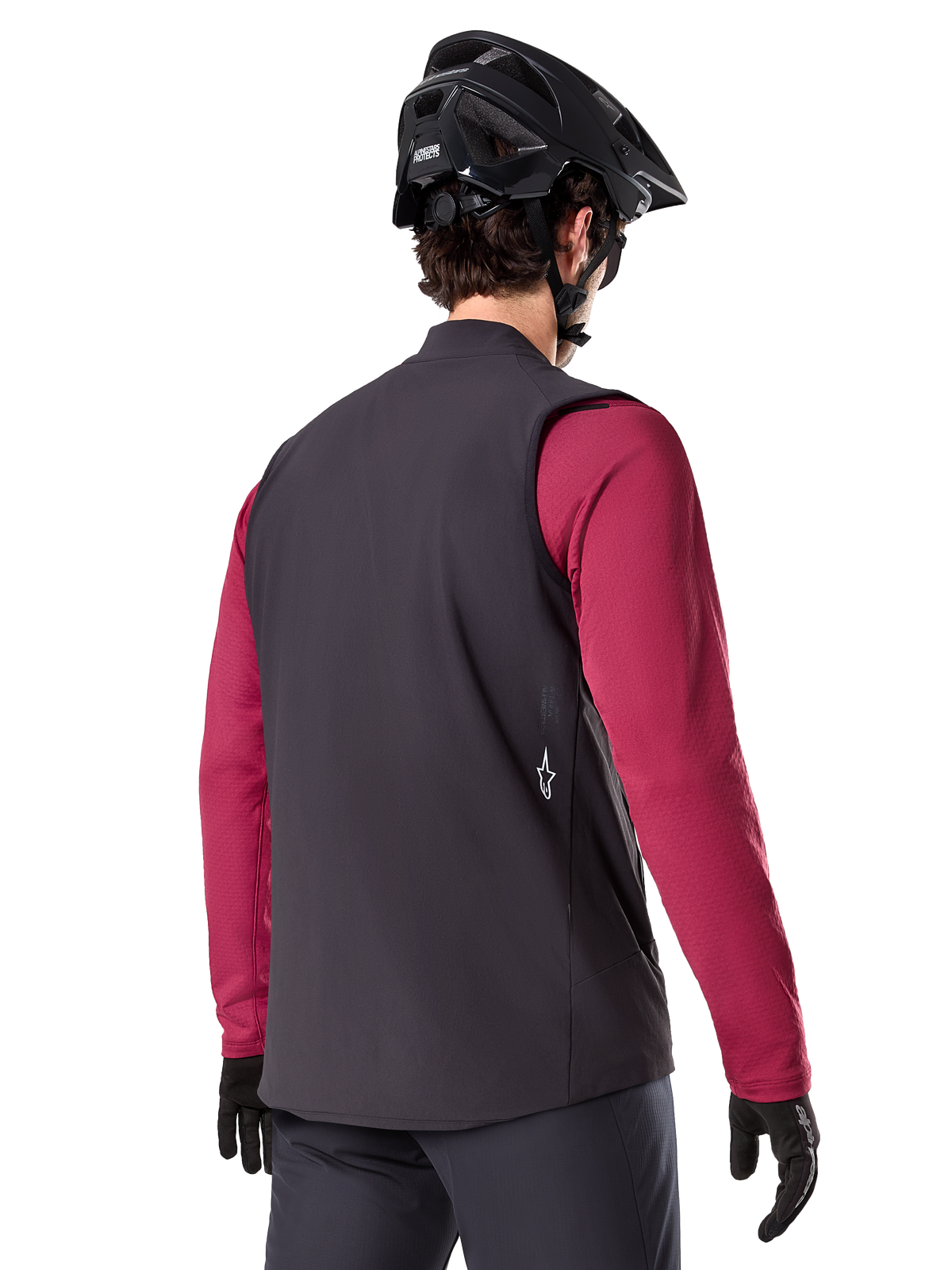 Alpinestars A-Dura Thermal Vest, Black, back view, worn over a maroon long-sleeve jersey with a black mountain bike helmet and gloves, lightweight insulated cycling gear for off-road riding
