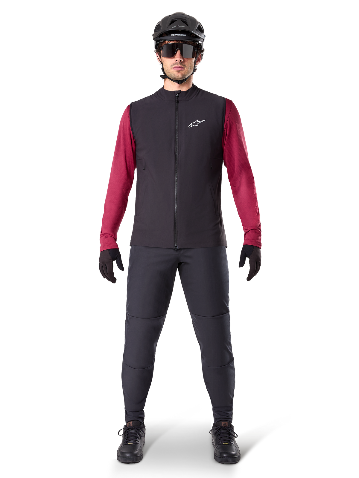 Alpinestars A-Dura Thermal Vest, Black cycling gilet worn over a maroon long-sleeve jersey, paired with dark grey MTB pants, black helmet and sunglasses, technical mountain bike apparel for cold-weather riding