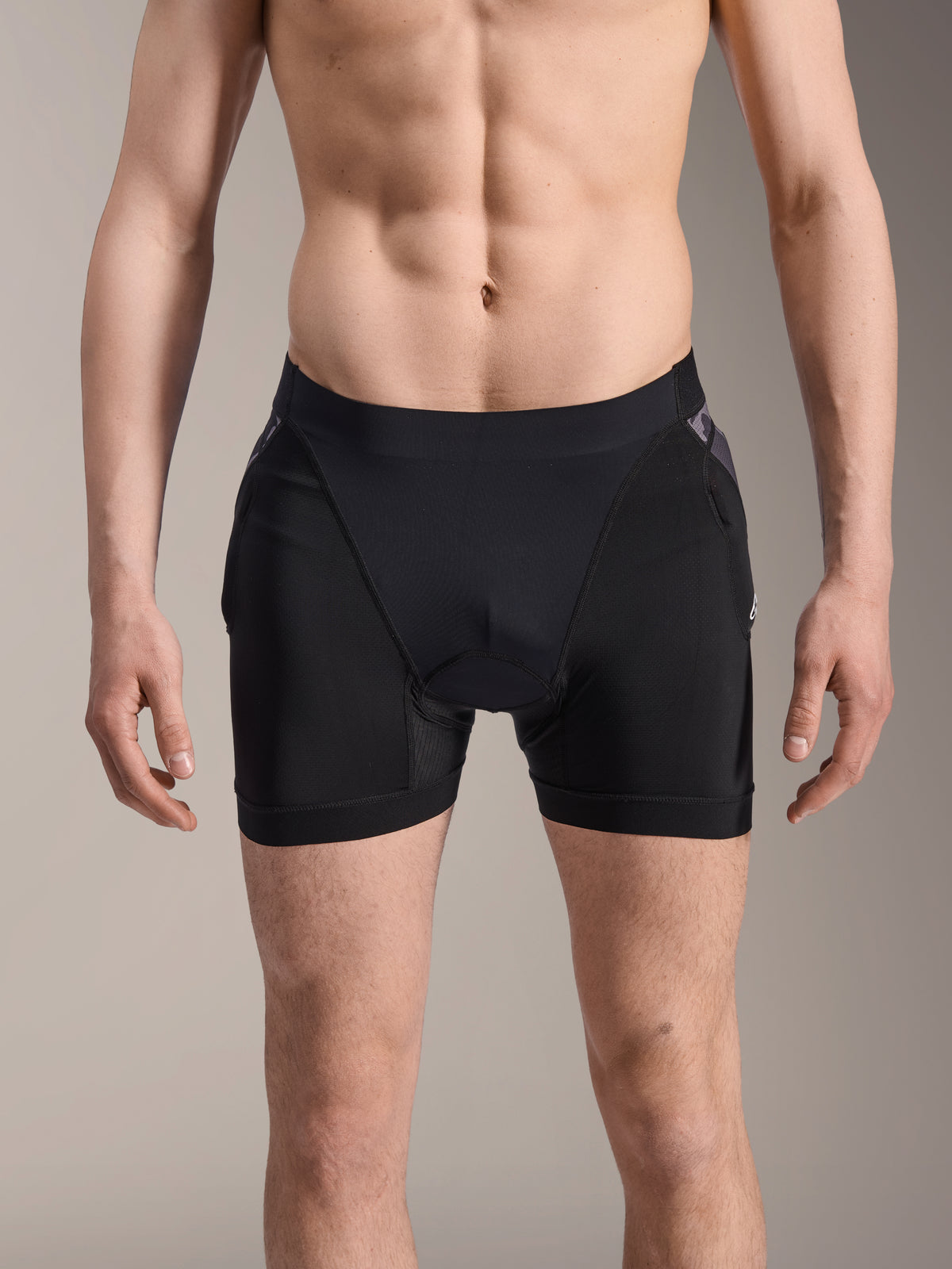 Alpinestars A-Motion Plasma Protection Boxers, MTB-skyddsshorts, svarta med svarta kamouflagedetaljer, framifrån på manlig modell, med ventilerande stretchmesh och integrerat höftskydd för cykelprestanda.